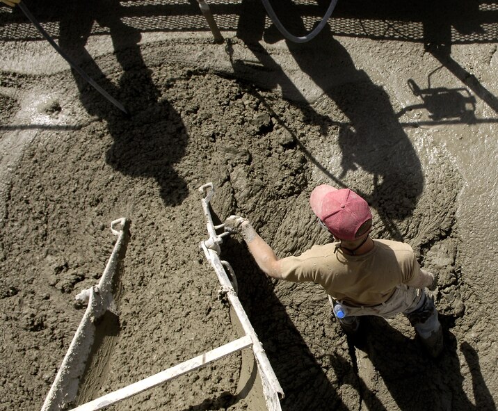Senior Airman Casey Anderson pours the concrete for a new ramp at Bagram Air Base, Afghanistan, June 5, 2006. Airman Anderson is a part of the 1st Expeditionary Red Horse Group. The ramp will house close air support aircraft, such as the A-10 Thunderbolt II. (U.S. Air Force photo/Senior Airman Brian Ferguson) 