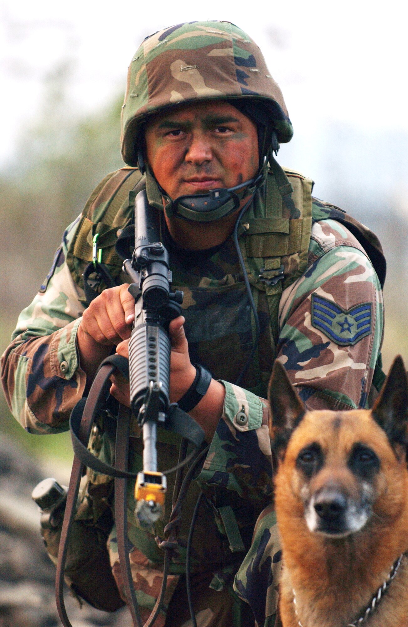 Staff Sgt. Steve Montez patrols the area with his military working dog in a simulated attack during a Commando Warrior class exercise at Osan Air Base, South Korea. Commando Warrior trains Airmen throughout the Pacific Air Forces area for deployments supporting the war on terrorism. Sergeant Montez is assigned to Kadena AB, Japan. (U.S. Air Force photo/Amn. Gina Chiaverotti)