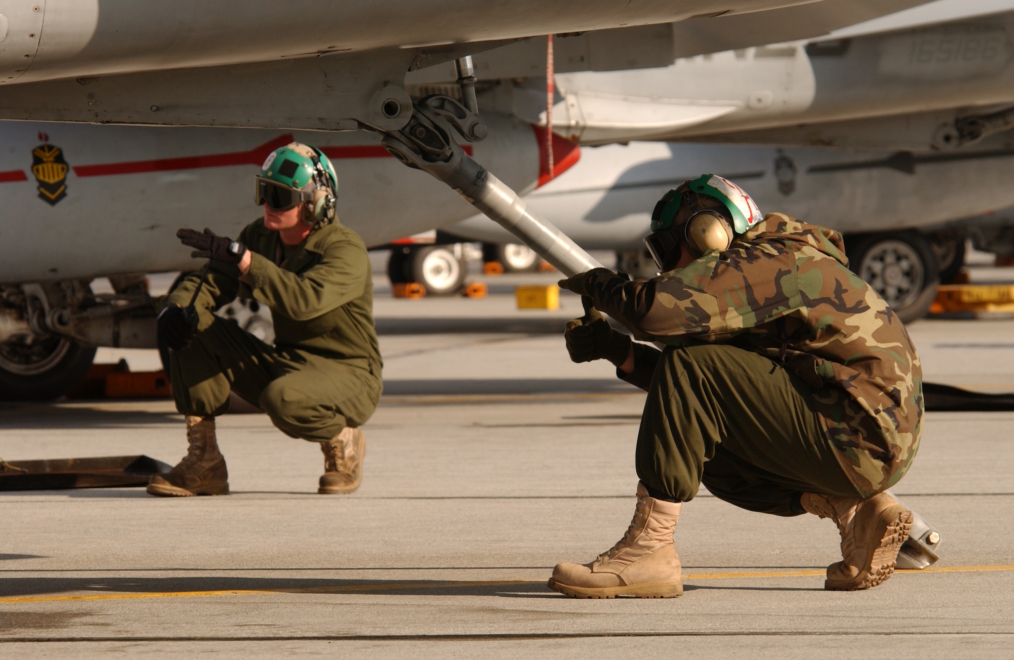 Two Marines from the 1st Marine Aircraft Wing in Okinawa use hand signals during an F/A-18 Hornet launch at Eielson Air Force Base, Alaska, on Tuesday, June 6, 2006, during exercise Northern Edge 2006. The joint training exercise hosted by Alaskan Command is one of a series of U.S. Pacific Command exercises that prepare joint forces to respond to crises in the Asian Pacific region. (U.S. Air Force photo/Staff Sgt. Joshua Strang)