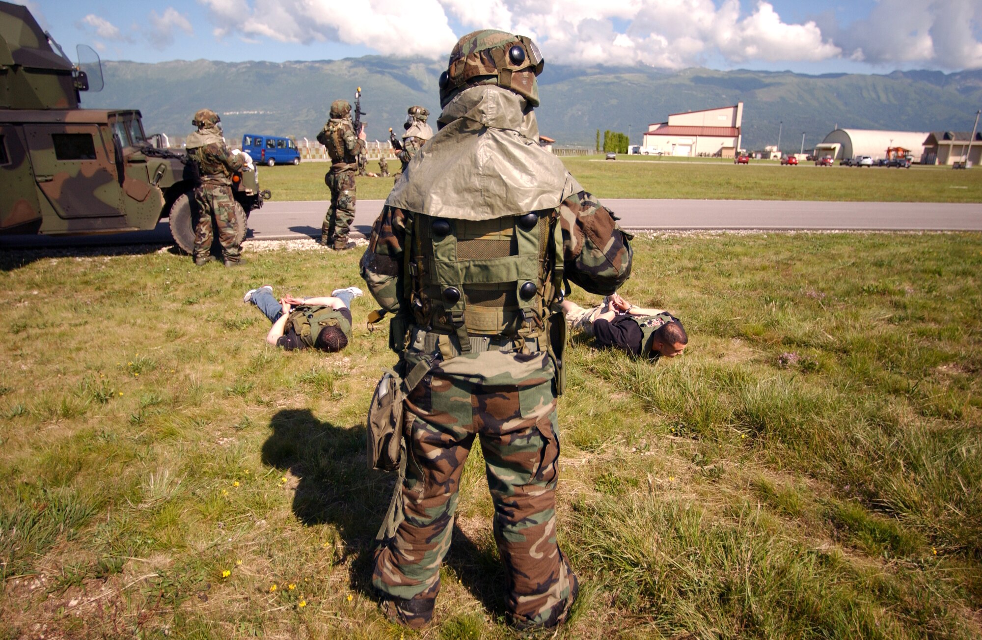 An Airman from the 31st Security Forces Squadron stands guard over "intruders" during a Local Salty Nation exercise at Aviano Air Base, Italy, on Wednesday, June 7, 2006. The exercise was conducted June 5 to 9. (U.S. Air Force photo/Staff Sgt. Bethann Caporaletti)
