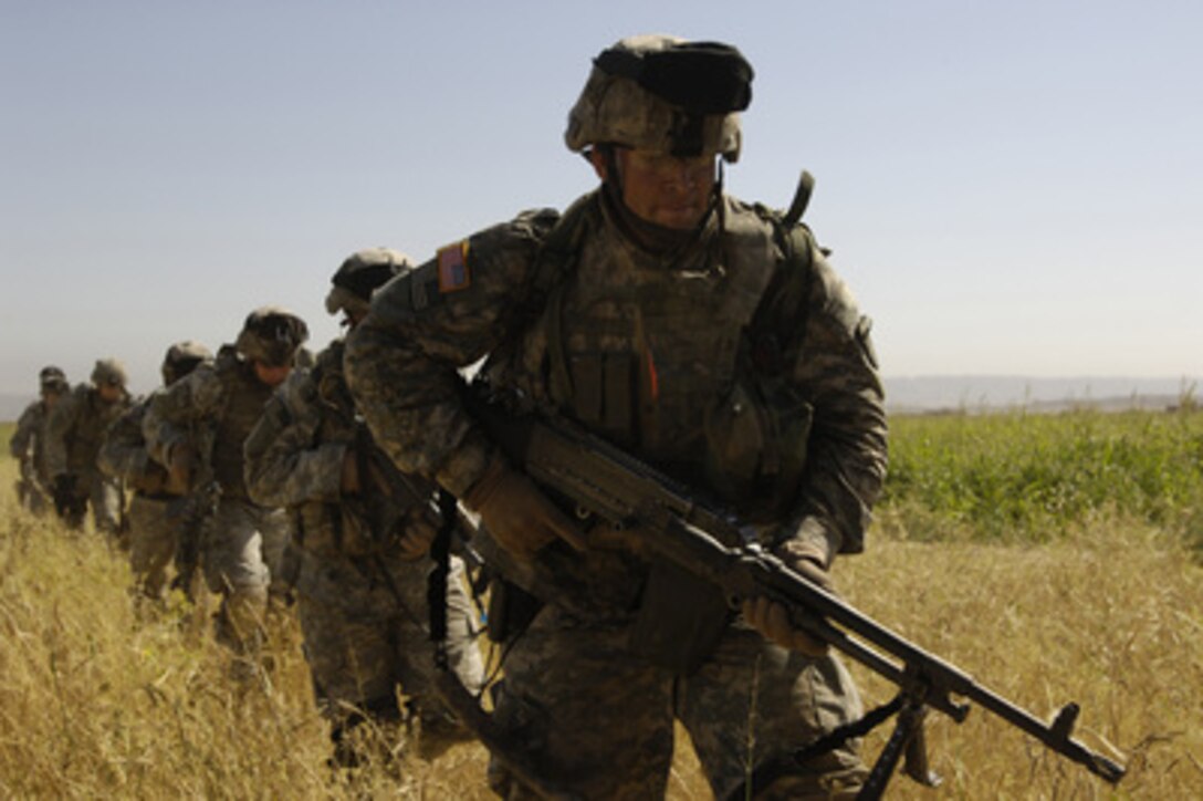 U.S. Army soldiers with the 1st Battalion, 187th Infantry Regiment run to board a CH-47D Chinook helicopter after completing a mission near Bayi, Iraq, on June 6, 2006. 