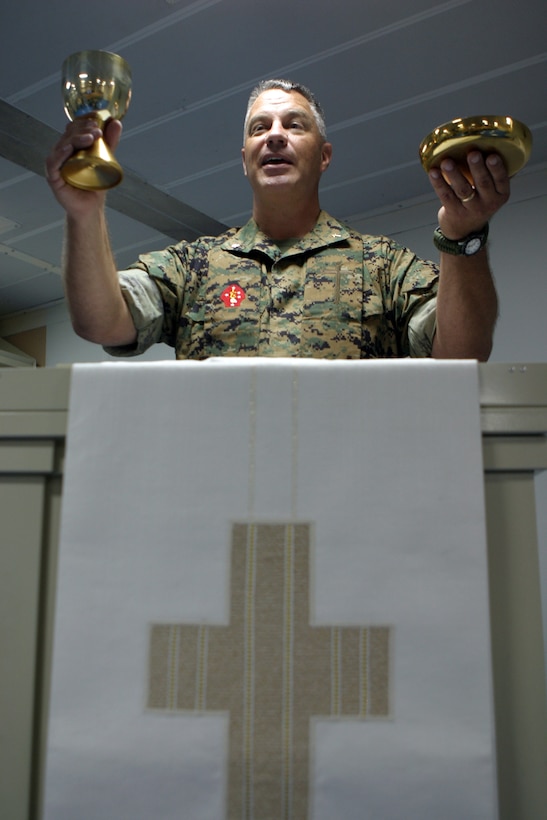 Navy Commander Gary W. Carr, 24th Marine Expeditionary Unit chaplain from Lansing, Mich., offers a blessing during a religious service while deployed aboard the USS Iwo Jima.  The 24th MEU last week began an expected six-month deployment to the European and Central Command theaters of operation.