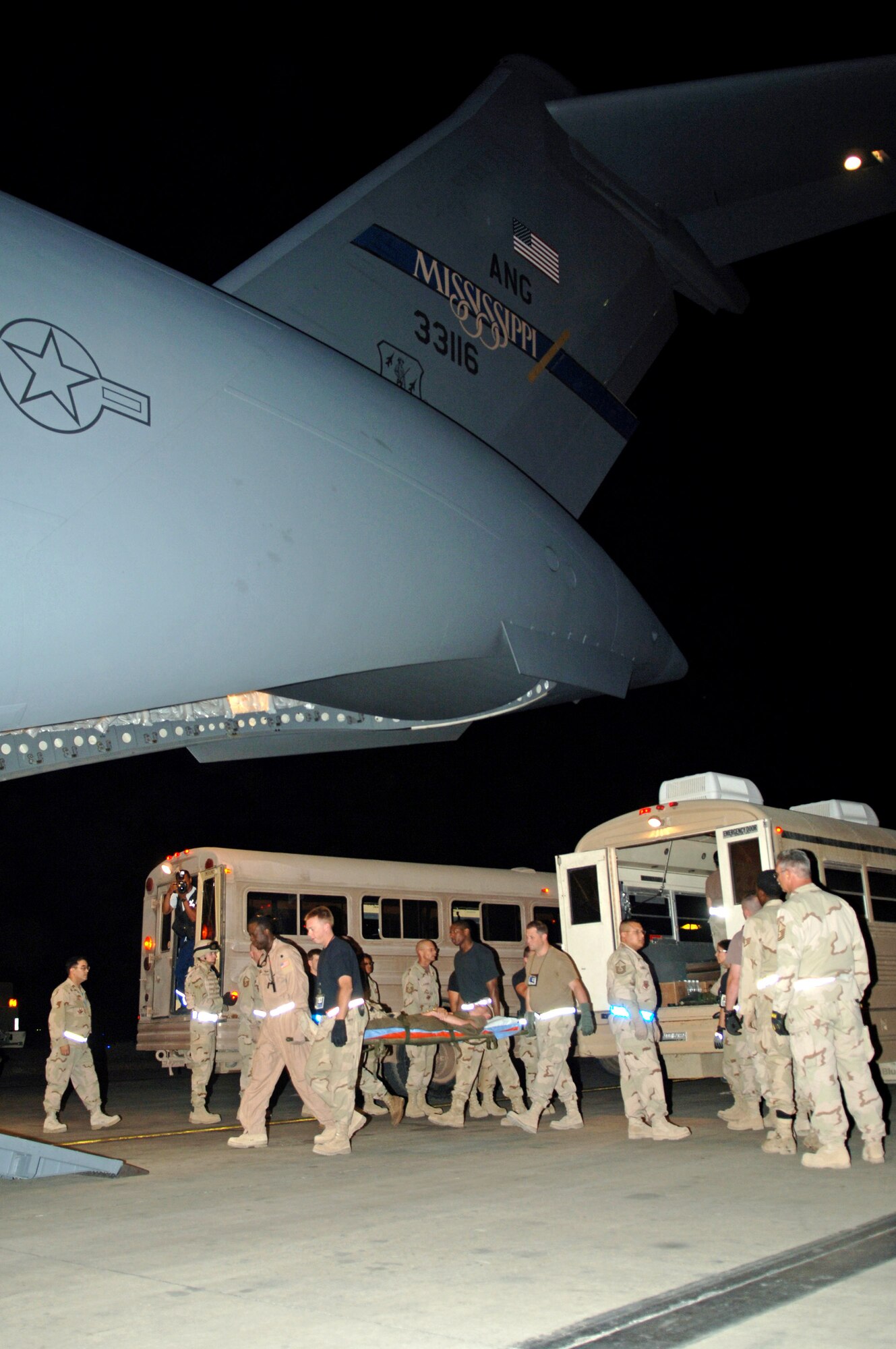 Airmen from the 721st Air Mobility Operations Group and 332nd Air Expeditionary Wing carry patients about to be aeromedically evacuated onto a C-17 Globemaster III at Balad Air Base, Iraq, on Friday, June 9, 2006. (U.S. Air Force photo/Staff Sgt. Tony R. Tolley)