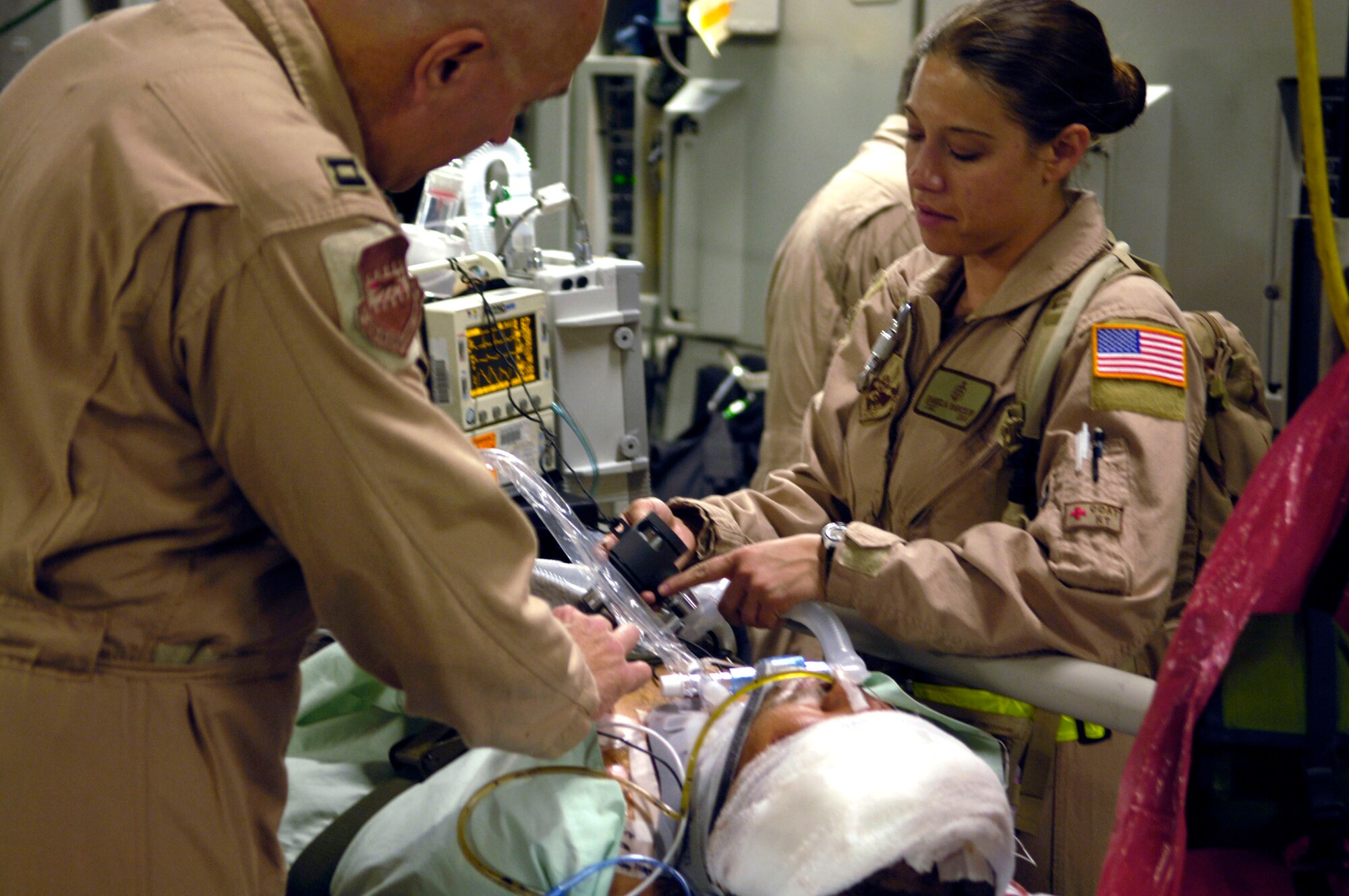 Capt. Gary Novak and Tech. Sgt. Daniela Rabickow prepare a patient about to be aeromedically evacuated from Balad Air Base, Iraq, aboard a C-17 Globemaster III on Friday, June 9, 2006. Captain Novak and Sergeant Rabickow are assigned to the 332nd Expeditionary Operations Support Squadron aeromedical evacuation flight. (U.S. Air Force photo/Airman 1st Class Andrew Oquendo) 
