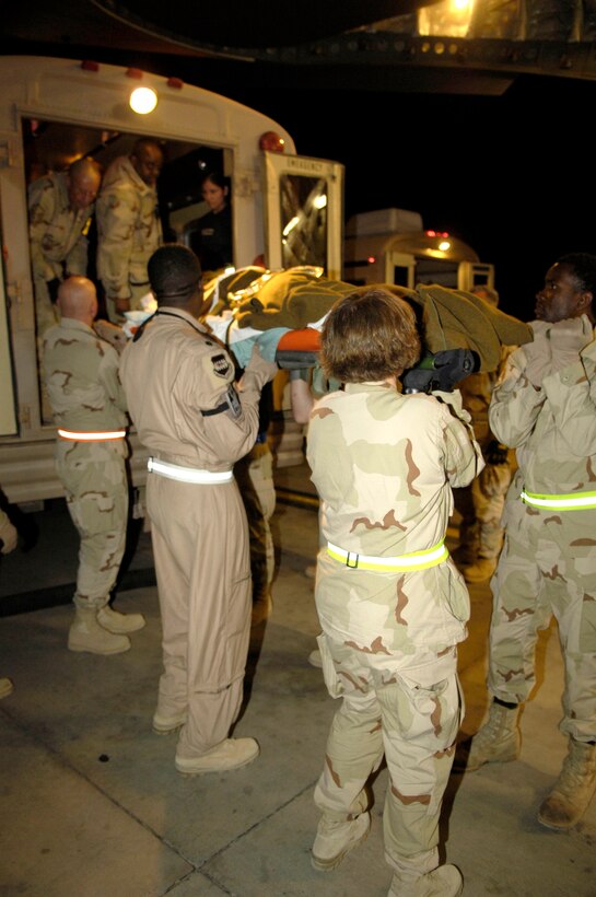 Airmen carry patients from a bus to a nearby aeromedical evacuation aircraft at Balad Air Base, Iraq, on Friday, June 9, 2006. (U.S. Air Force photo/Airman 1st Class Andrew Oquendo)