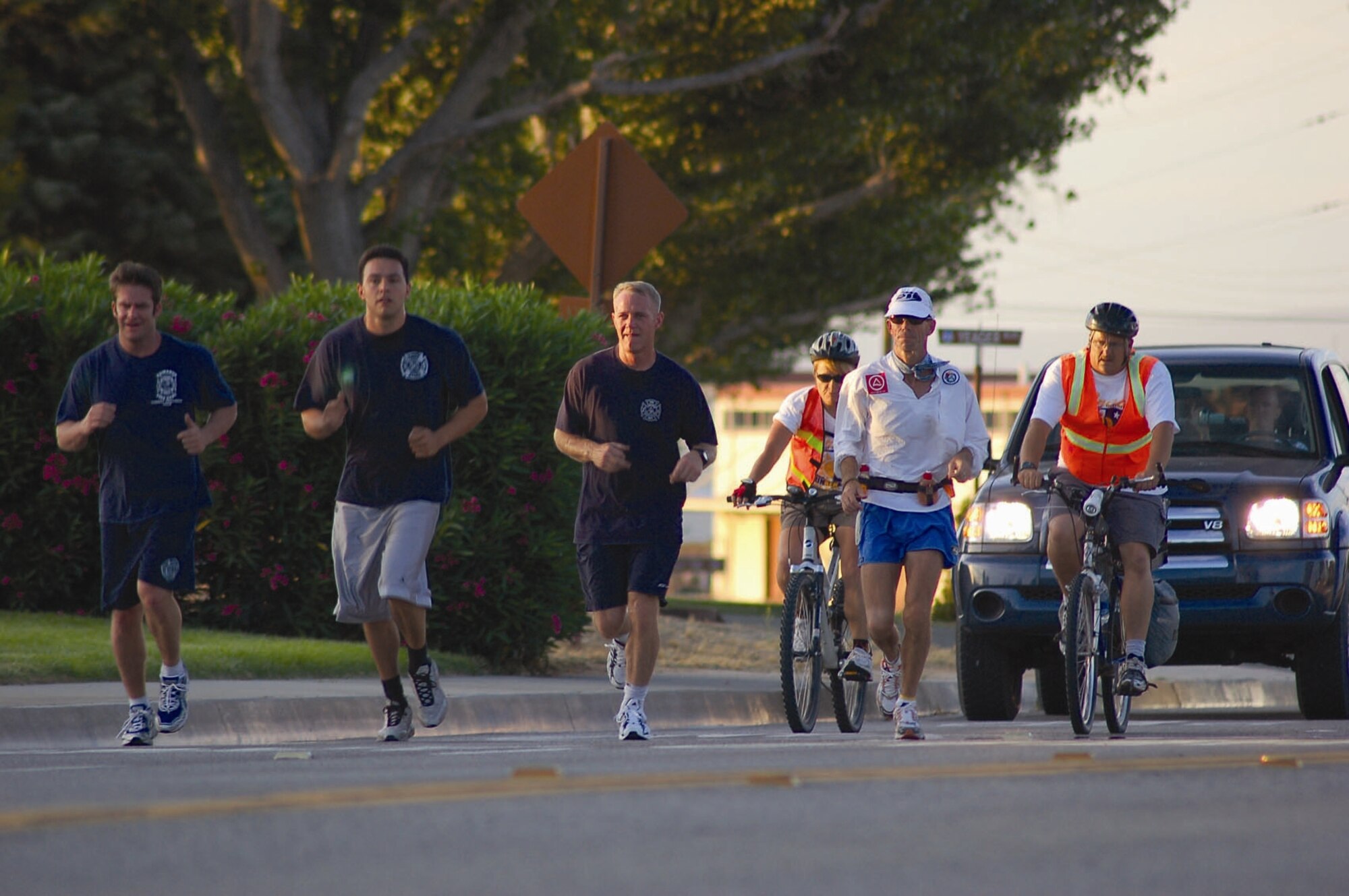 EDWARDS AIR FORCE BASE, Calif. — (From left to right) Edwards firefighters John Miller, Tyson Cardenas and Capt. Chris Lindsay run alongside former firefighter Ken Perry and two members from his medical team, bike riding, as Mr. Perry runs from the North Gate to the South Gate on June 2. Mr. Perry crossed Edwards as part of a 104.8-mile run benefiting the Wildland Firefighter Foundation, a non-profit organization that helps injured firefighters and the families of firefighters killed in the line of duty. (Air Force photo by Capt. Catie Hague)

