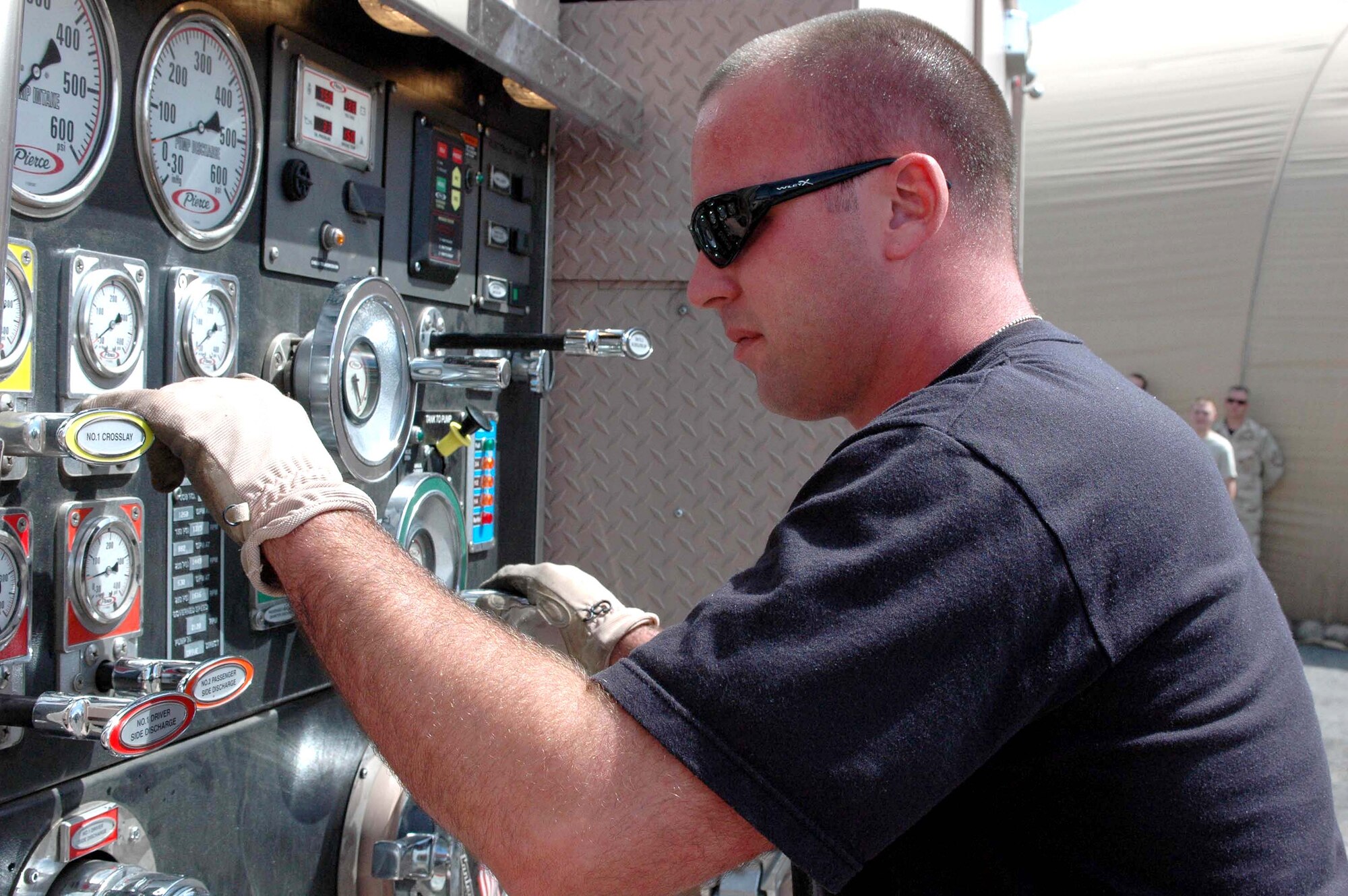 Senior Airman Ryan McClellan checks the water pressure on a firefighting vehicle at Manas Air Base, Kyrgyzstan, on Wednesday, June 7, 2006. The 376th Expeditionary Civil Engineer Squadron's fire department and Manas International Airport emergency response team held a joint training exercise June 6 to 7. Airman McClellan is deployed from Key Field Air Guard Station, Miss., and is assigned to the 376th ECES. (U.S. Air Force photo/Staff Sgt. Candy Knight)