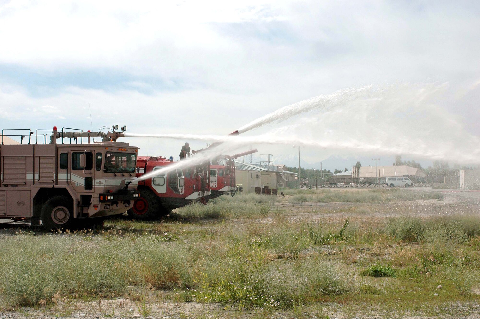 Firefighters from the 376th Expeditionary Civil Engineer Squadron fire department and Manas International Airport demonstrate their equipment at Manas Air Base, Kyrgyzstan, on Wednesday, June 7, 2006. The teams held a joint training exercise June 6 to 7. During the exercise, members from each department familiarized themselves with the different types of equipment used to fight different types of fires. (U.S. Air Force photo/Staff Sgt. Candy Knight)