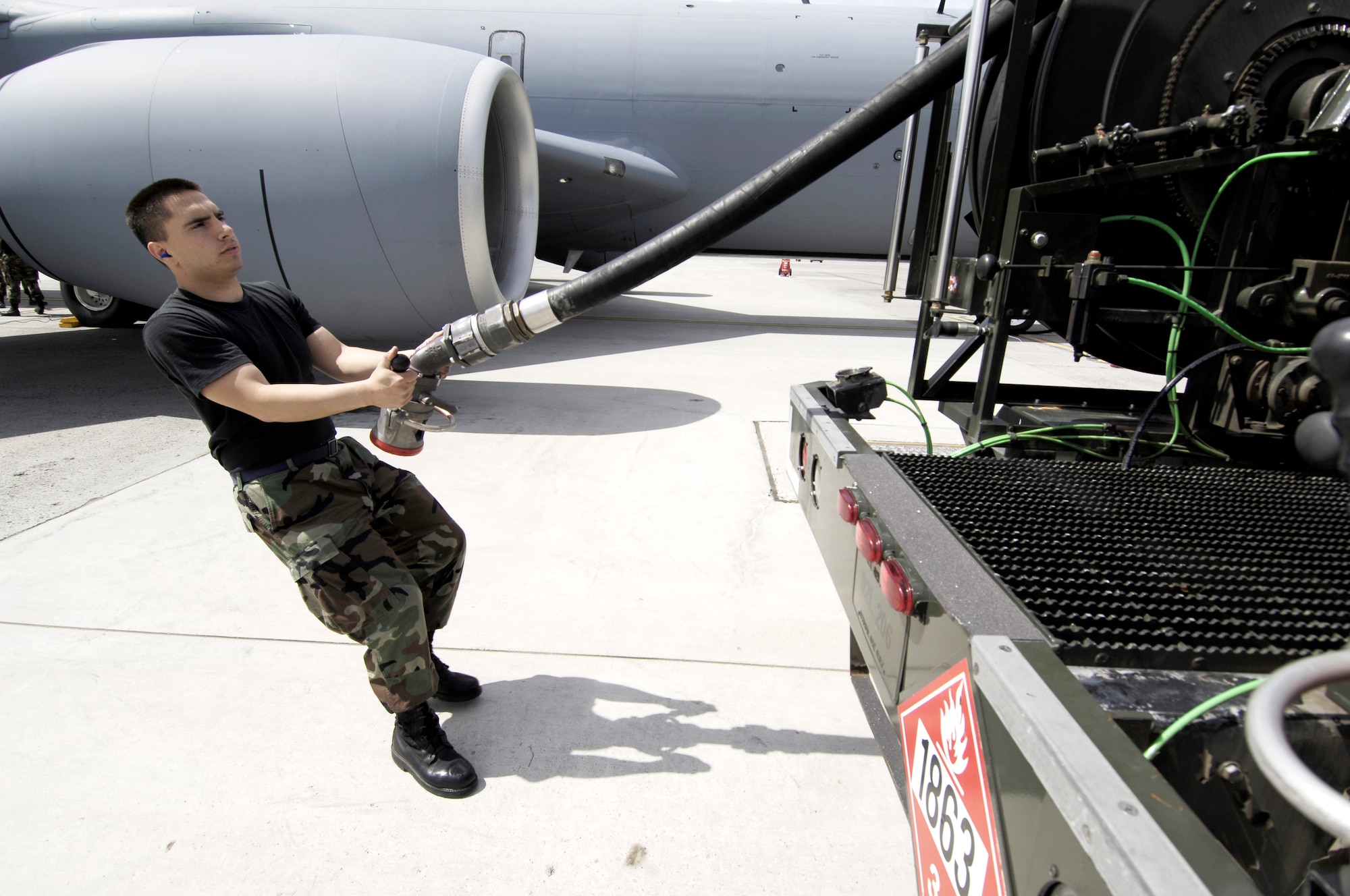 Airman Richard Hedden, 92nd Logistics Readiness Squadron fuels specialist, pulls out a single point fuel line as he prepares to refuel a KC-135. The hydrant service vehicle is capable of pumping up to 750 gallons per minute.