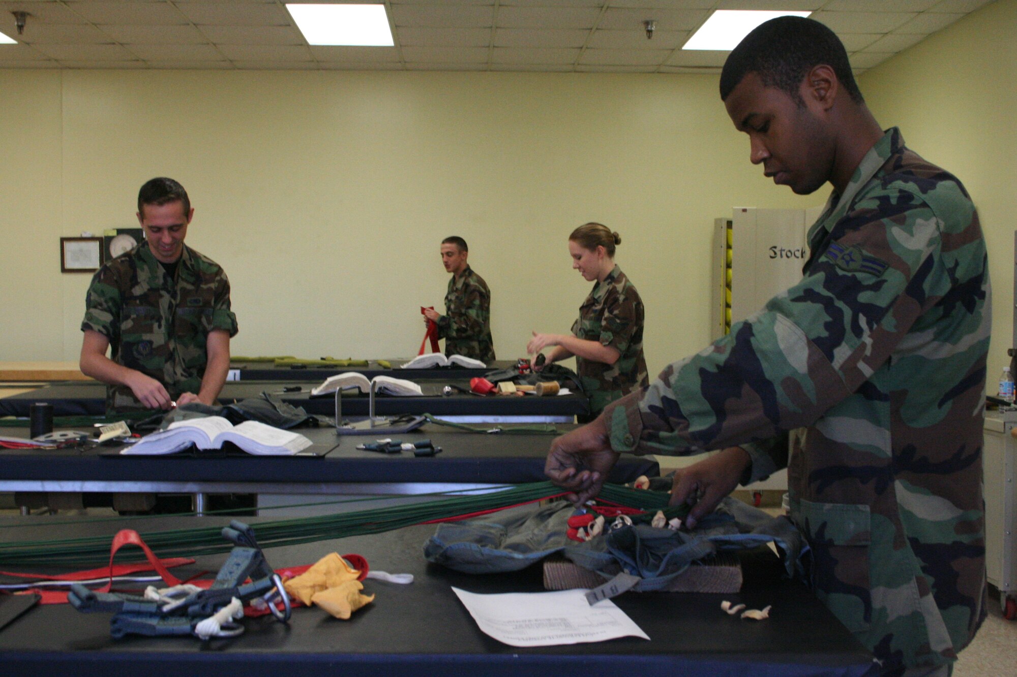 Airman 1st Class Morris Ross is completing the final steps of the parachute packing process.