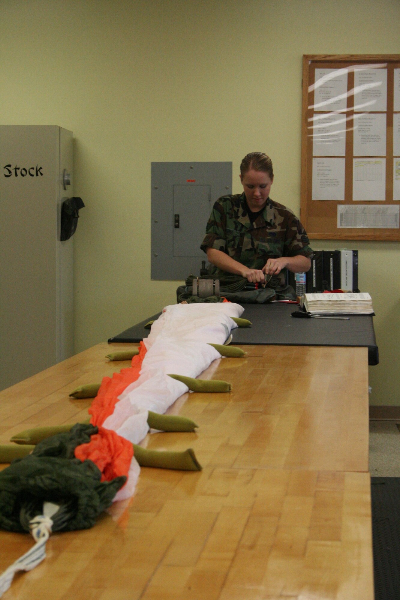 Airman 1st Class Rachel Medina prepares to pack a chute after she has inspected it .