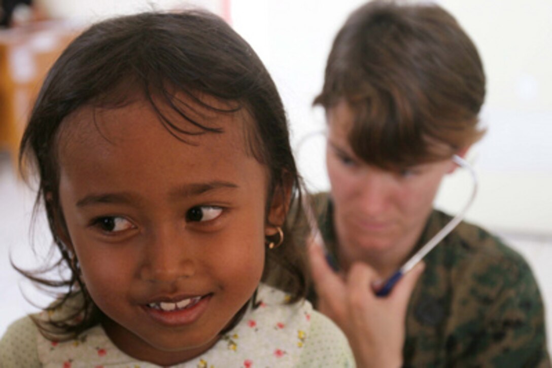 Navy Petty Officer 1st Class Tracey Waycaster examines a 7-year-old girl for injuries at the 3rd Marine Expeditionary Brigade's disaster assistance team's mobile hospital in Sewon, Indonesia, on June 3, 2006. The child suffered minor scrapes and bruises during the 6.2 magnitude earthquake that devastated Central Java, Indonesia. 