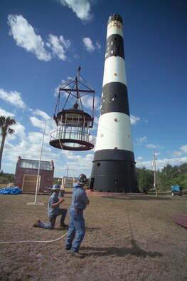 CAPE CANAVERAL AIR FORCE STATION, Fla.—Construction workers guide the 18,000-pound roof and lamp room to the ground from atop the 151-foot Cape Canaveral Lighthouse. The structures were removed as part of an ongoing renovation project. This is the first time the original lamp room has been separated from the lighthouse base in more than 100 years. 