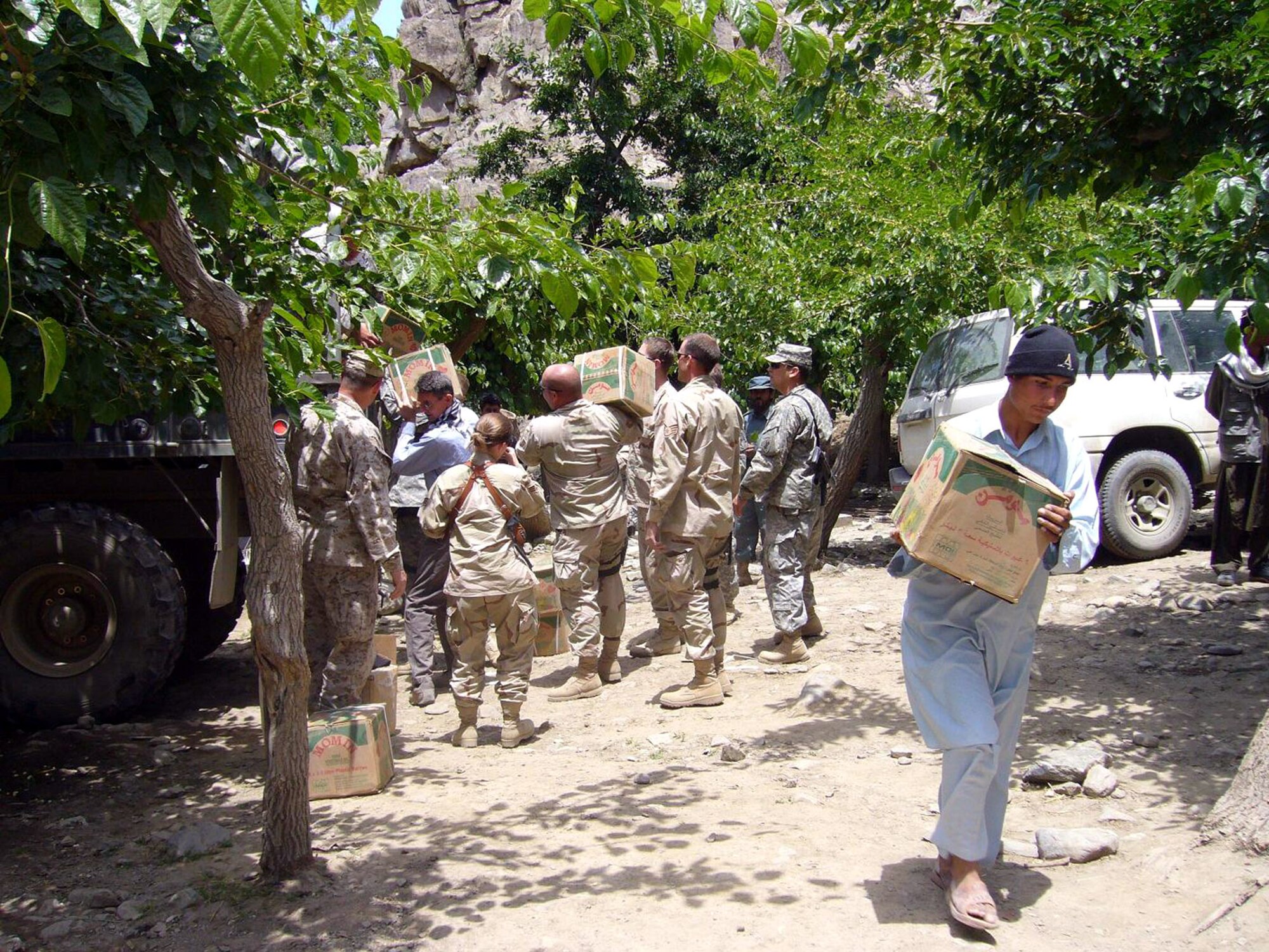 The Panjshir Provincial Reconstruction Team, members of the 405th Civil Affairs Battalion and a local villager offload bags and boxes of food at the Dara District Center in Afghanistan on Monday, June 12. (Courtesy photo/Shahla Hammond)