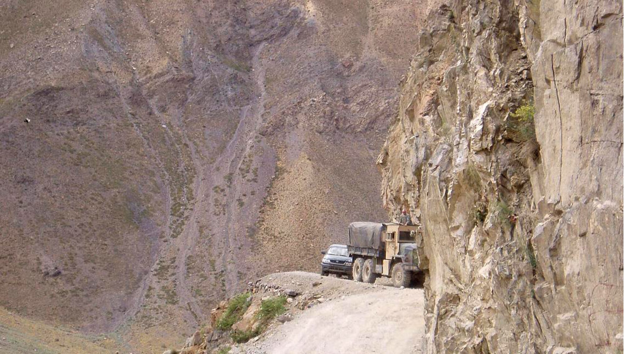 A truck loaded with humanitarian assistance supplies makes its way along a narrow road in the Panjshir Province, Afghanistan, on Monday, June 12. With help of a ground guide and spotter in the truck's turret, the multi-service supply convoy delivered approximately four tons of food to the village of Dara. (Courtesy photo/Tech. Sgt. Charles Campbell)