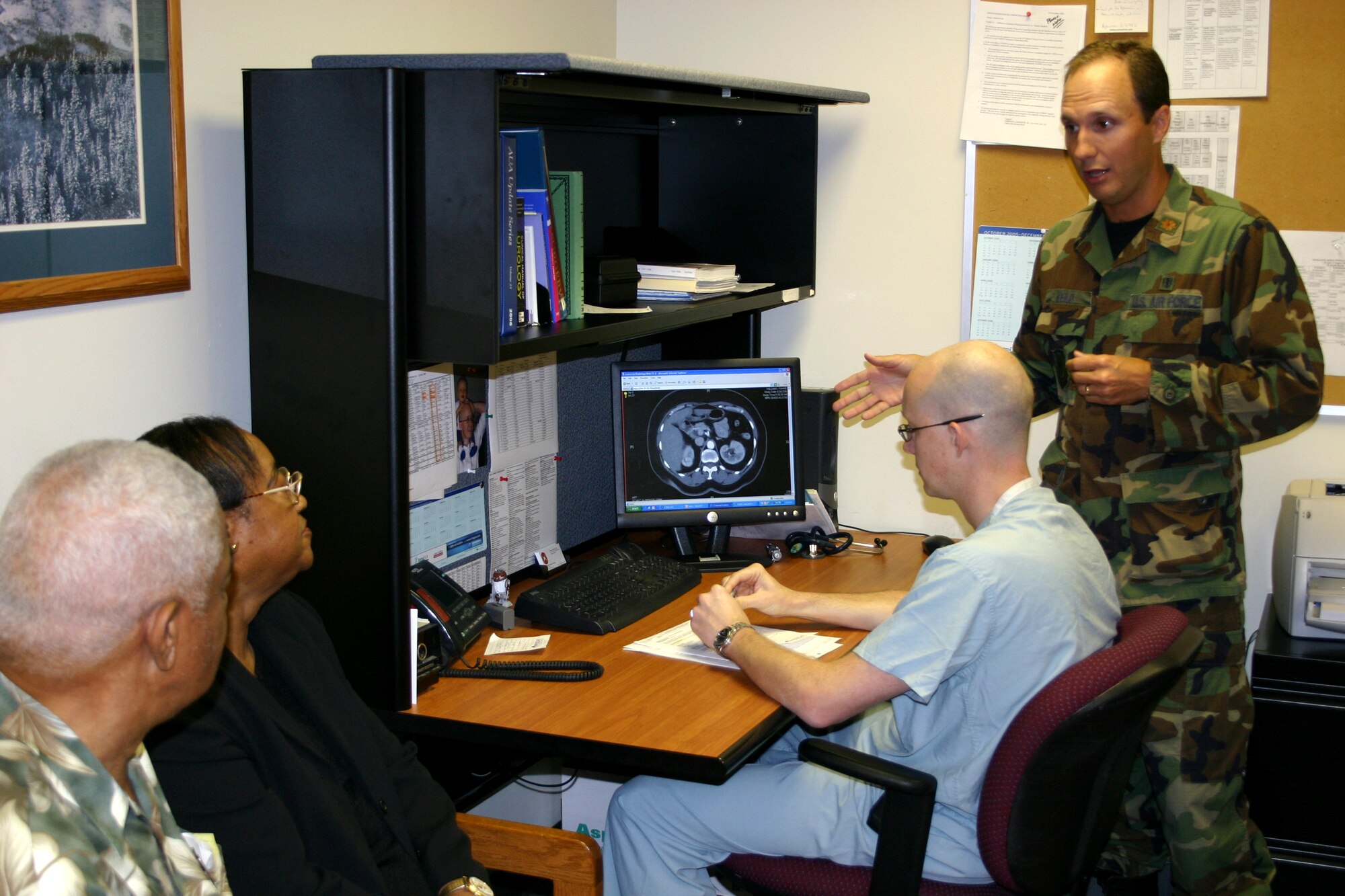Maj. (Dr.) Kyle Weld (right) discusses scan results with patient Fannie Williams, her husband, retired Senior Master Sgt. Thaddeus Williams, and Capt. (Dr.) William Kizer. Dr. Weld is the urology department assistant chief of staff and Dr. Kizer is the department's chief resident. (U.S. Air Force photo/Master Sgt. Kimberly Spencer) 
