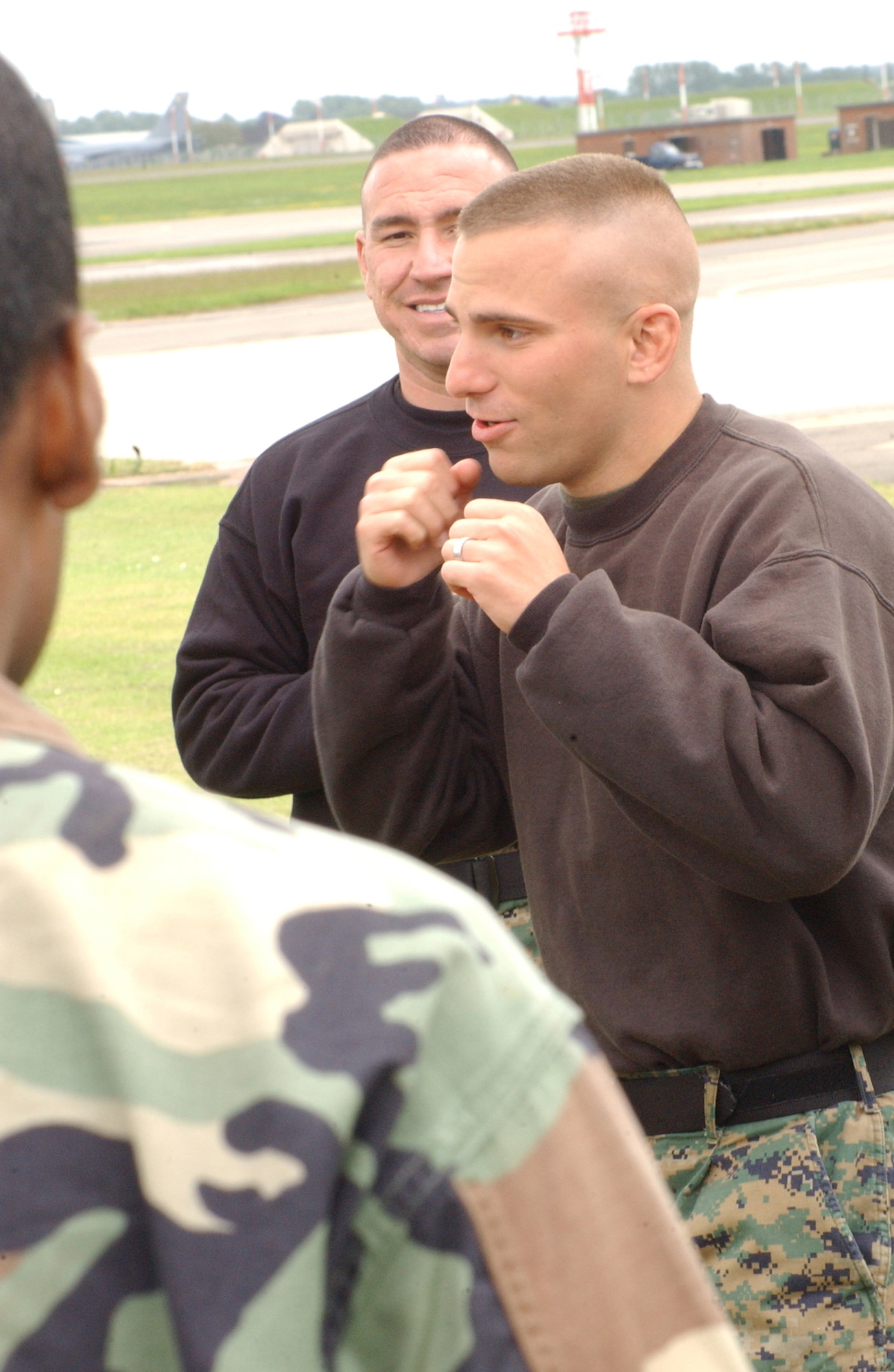 Marine Sergeant Thomas Lee, right, and Marine Gunnery Sergeant Richard Torrez, center, both Marine Corps Martial Arts Program instructors, talk to 100th Security Forces Squadron members May 22 during a week-long, combat-training course at RAF Mildenhall. The Marines visited from Quantico, Va. from May 15 to 26 to teach two week-long courses in combat training to security forces members.  (U.S. Air Force photo by Senior Airman Cecil McCloud)