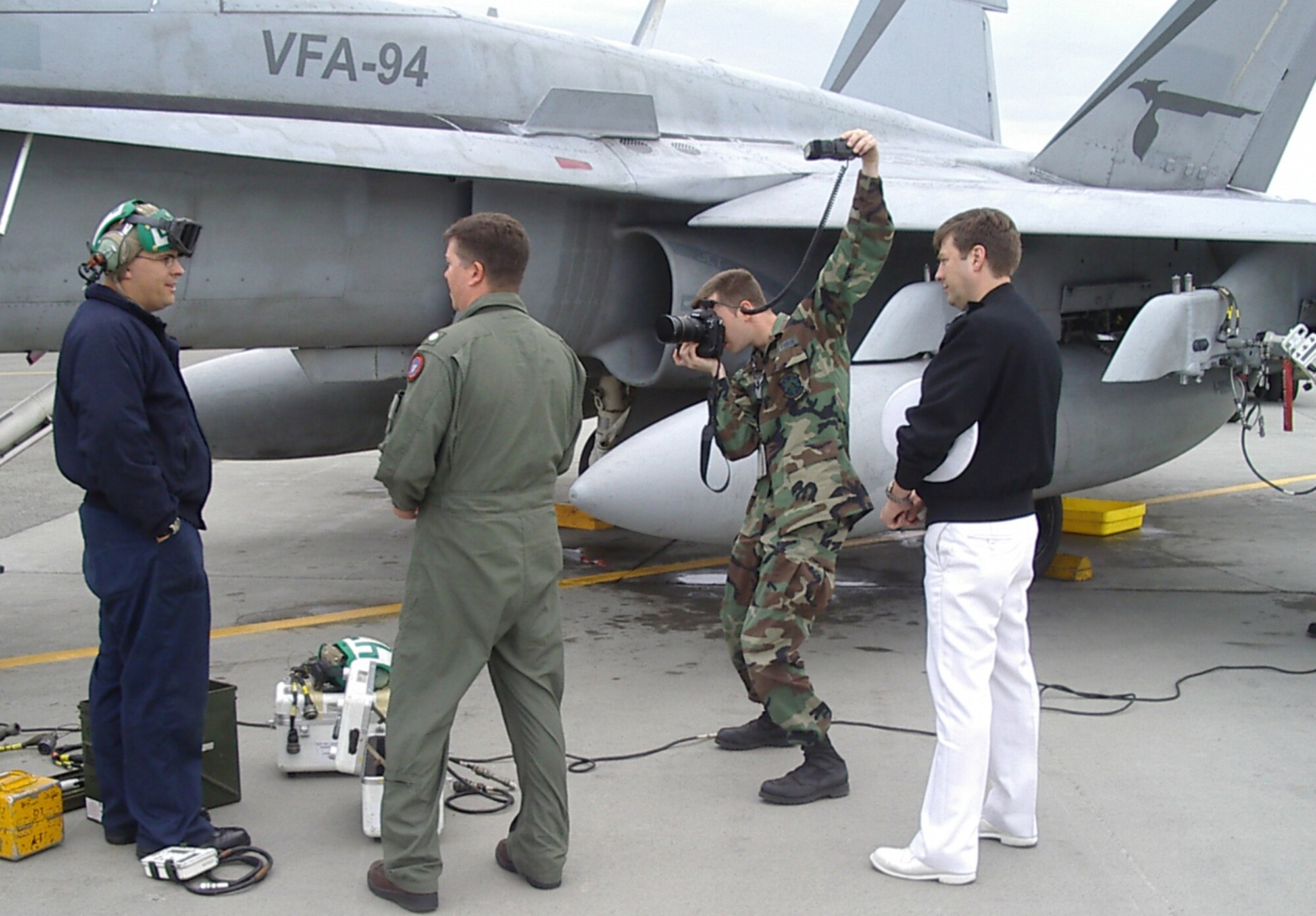(United States Air Force Photo by Maj. Richard Sater) (RELEASED)
ELMENDORF AIR FORCE BASE, Alaska -- Senior Airman Garrett Hothan and Navy Lt. Mike Flint, members of the Northern Edge 2006 Joint Information Bureau, document an interaction between Navy Cmdr. William Ipock and an F/A-18C Hornet maintainer on the Elmendorf flightline.  The JIB is a central clearinghouse for information about Northern Edge, the largest joint exercise in Alaska. 