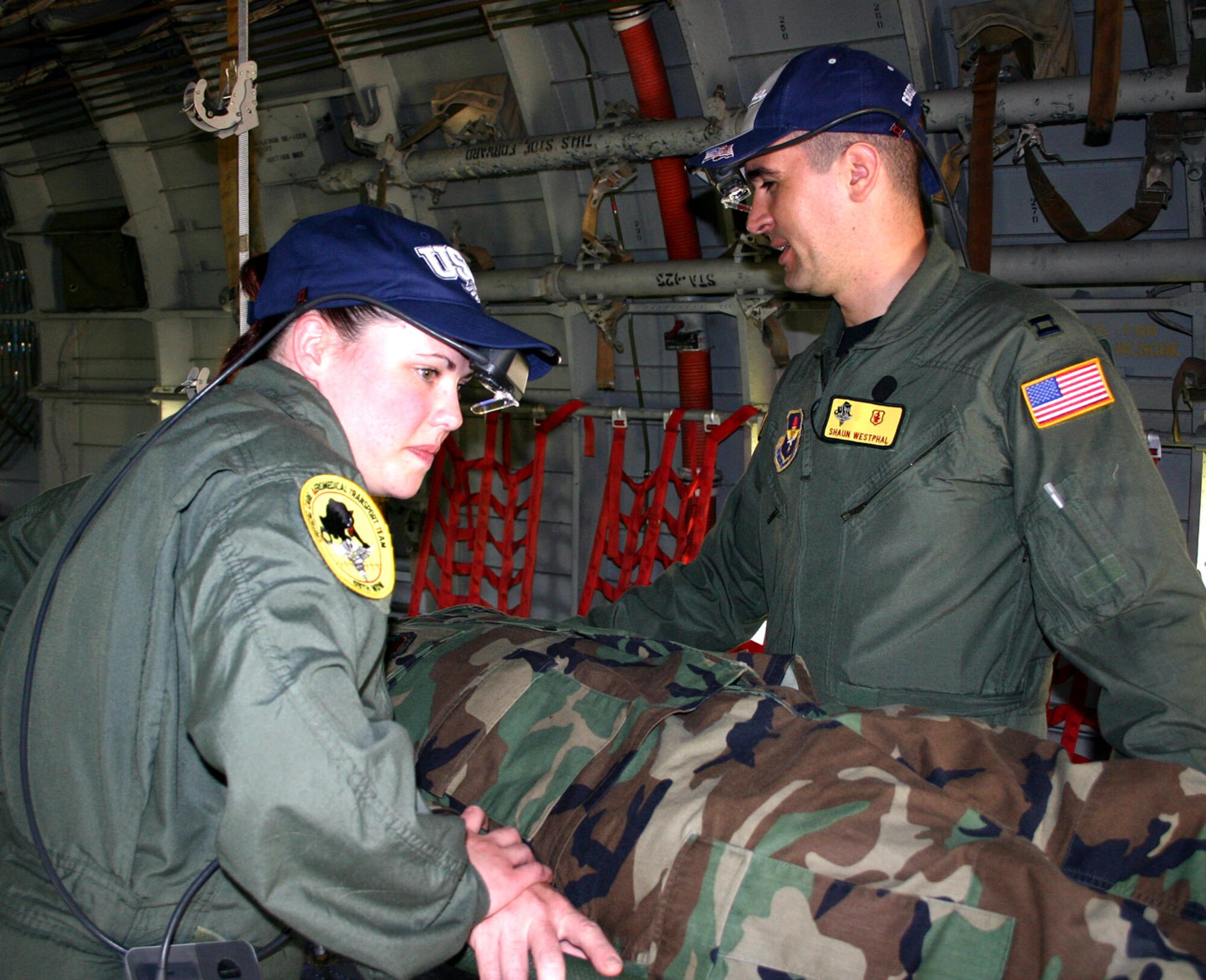 Critical care air transport team members Staff Sgt. Michelle Ransdell and Capt. Shaun Westphal simulate usage of medical heads-up displays, or MHUDs, on a C-123 Caribou at Lackland Air Force Base, Texas. The MHUDs were developed by staff at the Air Warfare Battlelab at Mountain Home Air Force Base, Idaho. The hats were props used during the evaluation phase. (U.S. Air Force photo/Sue Campbell)
