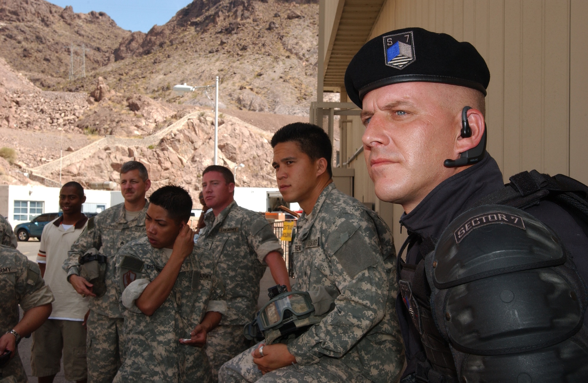 NELLIS AIR FORCE BASE, Nev. -- Nellis Airmen look on during filming of the Transformers movie on location at the Hoover Dam June 9, while waiting for their opportunity to get in front of the camera. Sixty-five Airmen from Nellis served as extras for the film, playing Army medivac troops, Sector-7 commandos, Hoover Dam security guards and tourists. Filming began at Hoover Dam June 8 and ended Saturday. U.S. (U.S. Air Force photo/Staff Sgt. Kenny Kennemer)  