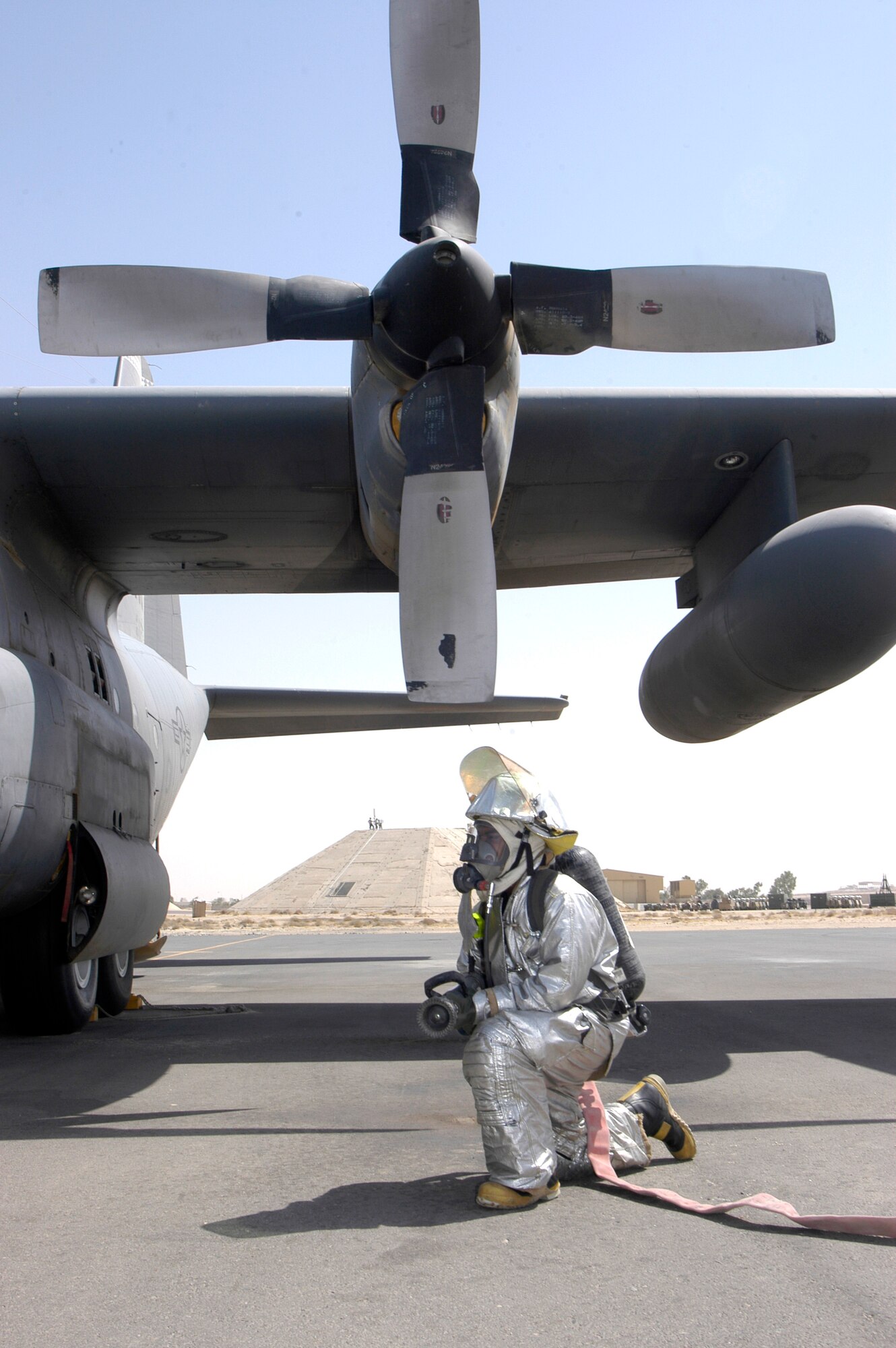 Airman 1st Class Donalyvn Smith is ready to respond during C-130 Hercules egress training at a deployed location in Southwest Asia on Wednesday, June 14. The firefighter is assigned to the 386th Expeditionary Civil Engineer Squadron and is deployed from Shaw Air Force Base, S.C. (U.S. Air Force photo/Staff Sgt. Ryan Hansen) 
        