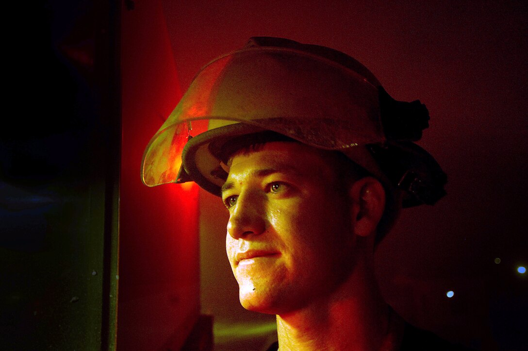 John Ode from contractor Wackenhut Fire and Emergency Service stays with the fire truck while fellow firefighters battle a blaze at Forward Operating Base Marez in Mosul, Iraq, on Thursday, June 8. The fire was at a local restaurant and jewelry store. (U.S. Air Force photo/Tech. Sgt. Jeremy T. Lock) 
