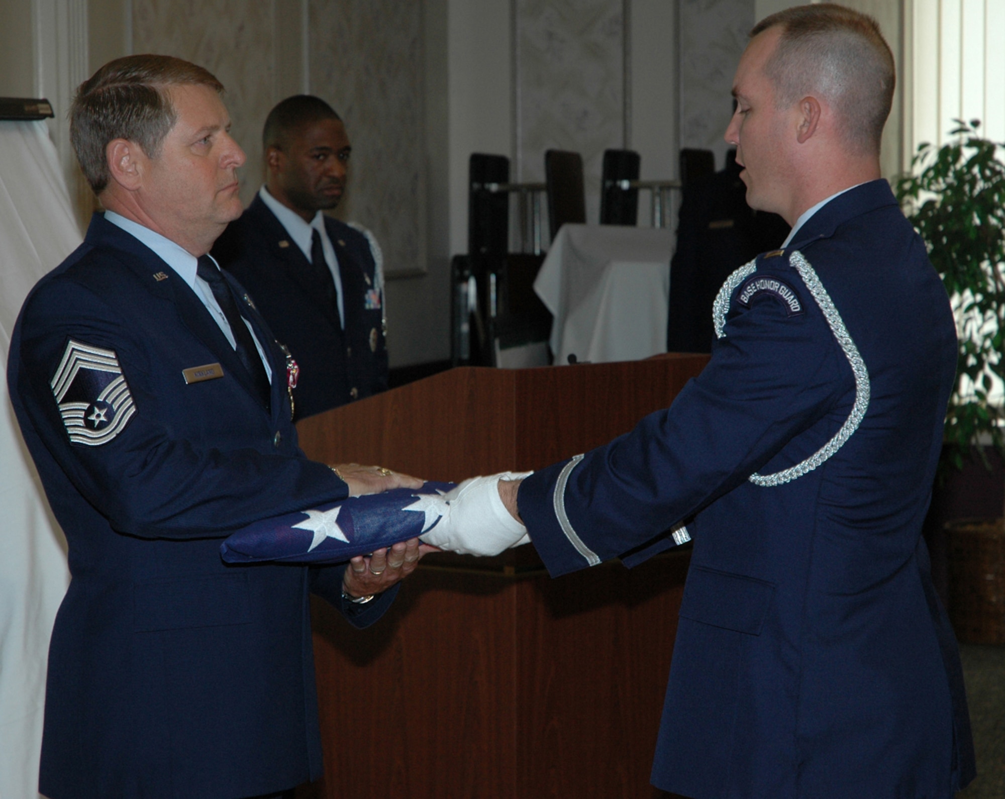 YOUNGSTOWN AIR RESERVE STATION, Ohio - Air Force Reserve Chief Master Sgt. Dennis L. Kirkland, former Command Chief of the 910th Airlift Wing, accepts a U.S. Flag from Air Force Reserve 2nd Lt. Scott Allen of the 910th Airlift Wing Honor Guard during the Chief's retirement ceremony held here June 4.  Chief Kirkland retired with more than 36 years service to his country.  U.S. Air Force Photo/Master Sgt. Bryan Ripple