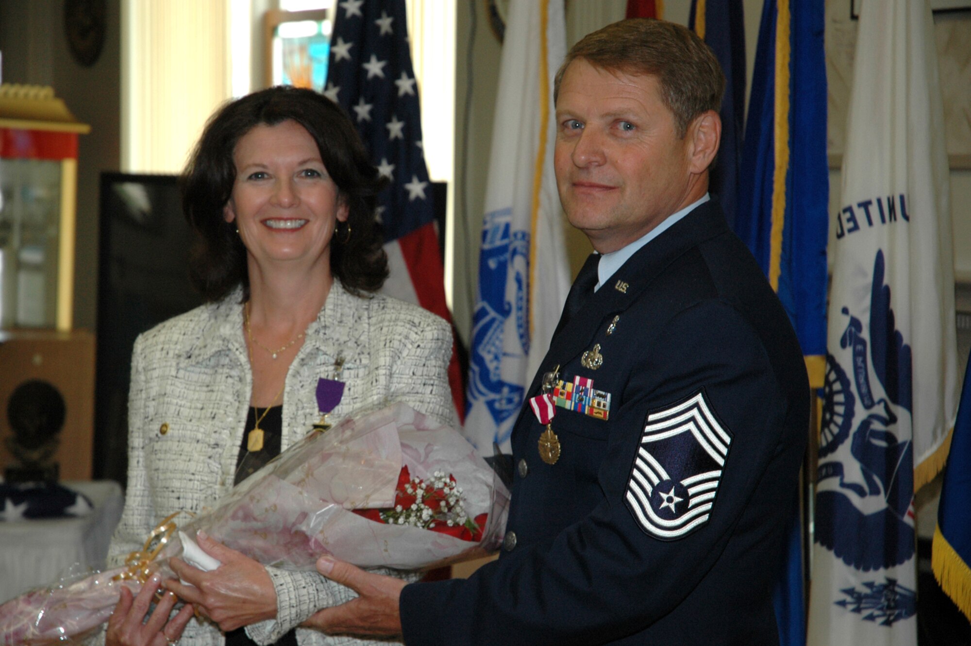 YOUNGSTOWN AIR RESERVE STATION, Ohio -- Air Force Reserve Chief Master Sgt. Dennis L. Kirkland presents a bouquet of flowers to his wife Debbie during the Chief's retirement June 4 retirement ceremony here.  Chief Kirkland spent nearly all of his 36-year career with the 910th Airlift Wing.  He was also the Command Chief for 4th Air Force, with headquaters at March Air Reserve Base, Calif. from Jan. 2003 to June 2005.  U.S. Air Force Photo/Master Sgt. Bryan Ripple