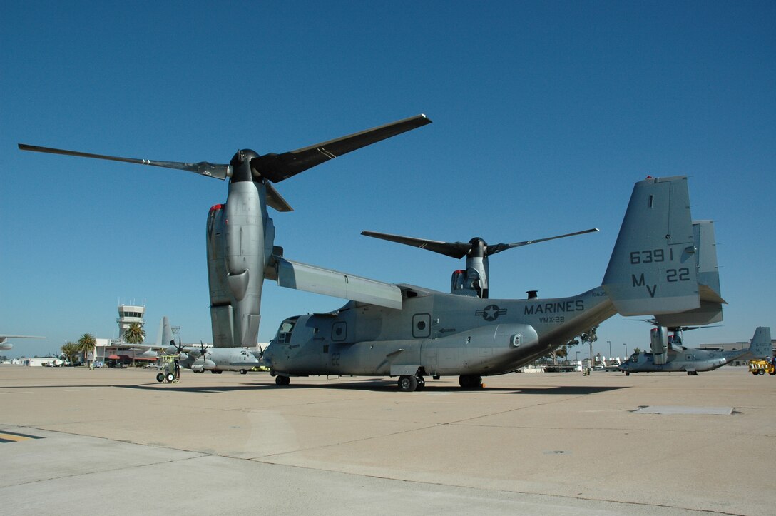 Two MV-22 Ospreys with Marine Tiltrotor Test and Evaluation Squadron 22 sit on the flightline near the air operations tower at Marine Corps Air Station Miramar, Calif., June 14.  The Ospreys, accompanied by two KC-130J Hercules aerial refueling aircraft, performed the long distance flight of more than 2,000 miles to Miramar to experiment with the self deployment of the aircraft.