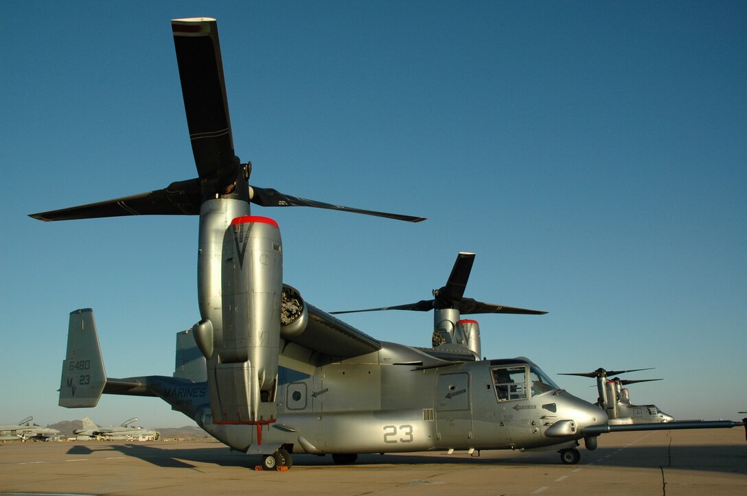 Two MV-22 Ospreys with Marine Tiltrotor Test and Evaluation Squadron 22 sit on the flightline near the air operations tower at Marine Corps Air Station Miramar, Calif., June 14.  The Ospreys, accompanied by two KC-130J Hercules aerial refueling aircraft, performed the long distance flight of more than 2,000 miles to Miramar to experiment with the self deployment of the aircraft.