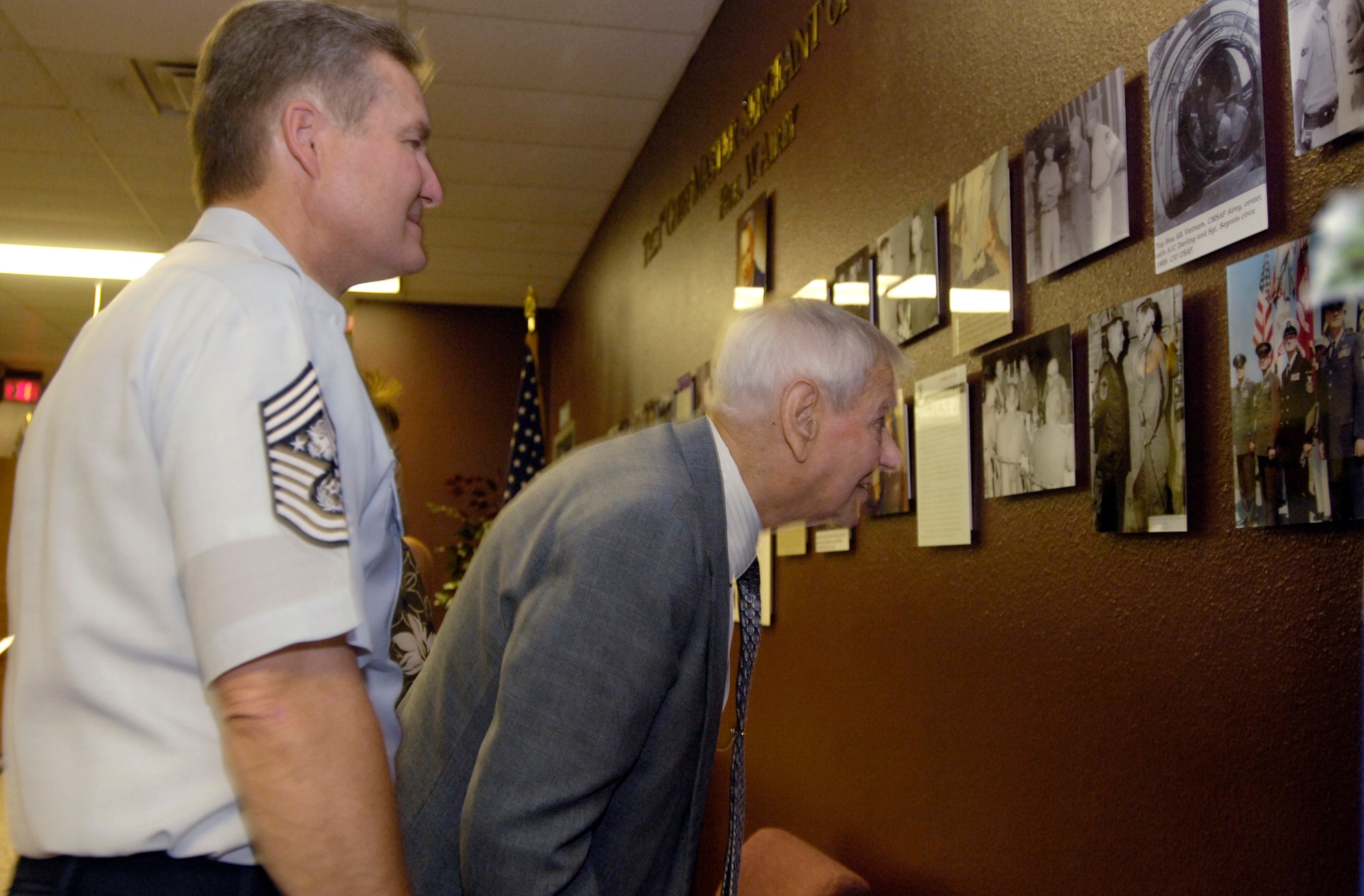 The first and current Chief Master Sergeants of the Air Force, Paul W. Airey and Gerald R. Murray, view a photographic memorial dedicated to Chief Airey at the Airey Processing Center at Lackland Air Force Base, Texas, on Wednesday, June 14. The building, formerly the 319th Processing Center, was one of nine training facilities dedicated to nine enlisted Air Force heroes who have served from World War II to present-day operations in the war on terrorism. The ceremony was part of a three-day event to honor the 60th anniversary of basic military training. (U.S. Air Force photo/Master Sgt. D. Scott Wagers)