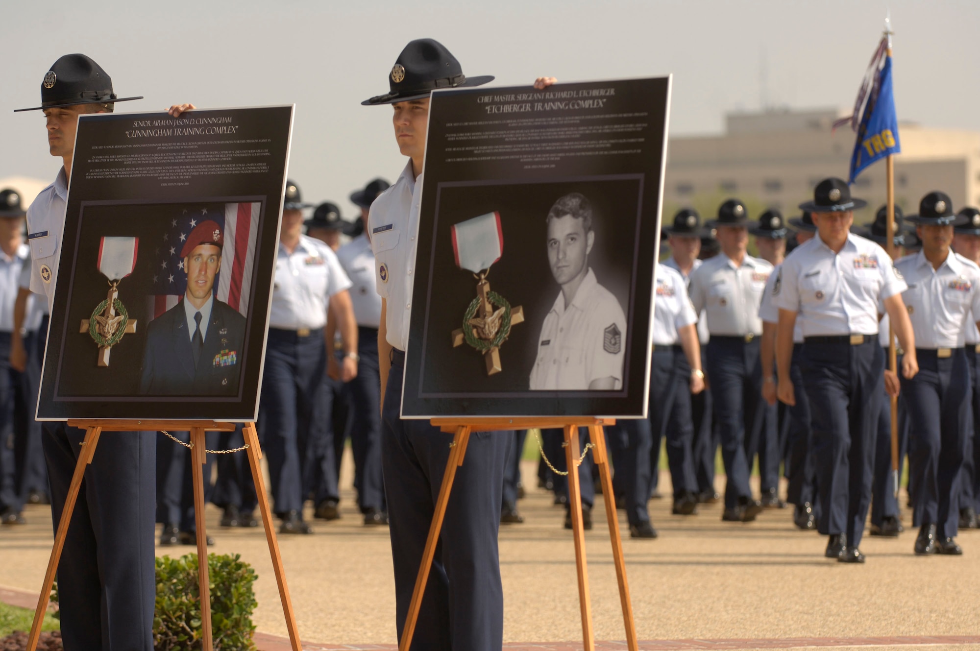 Military training instructors stand by photographs of Senior Airman Jason Cunningham and Chief Master Sgt. Richard Etchberger. They and seven other Airmen were memorialized in a Basic Military Training Memorialization Ceremony at Lackland Air Force Base, Texas, on Wednesday, June 14. Several hundred people witnessed the ceremony that dedicated nine training facilities in honor of nine enlisted heroes who have served from World War II to present-day operations in the war on terrorism. (U.S. Air Force photo/Master Sgt. D. Scott Wagers)