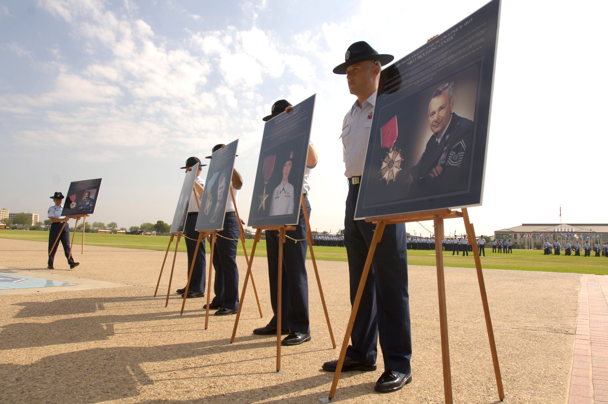 Military training instructors stand by photographs of former Chief Master Sergeant of the Air Force Paul W. Airey and eight other enlisted heroes who were honored at a Basic Military Training Memorialization Ceremony at Lackland Air Force Base, Texas, on Wednesday, June 14. Several hundred visitors witnessed the ceremony that dedicated nine training facilities in honor of nine enlisted heroes who have served from World War II to present-day operations in the war on terrorism. (U.S. Air Force photo/Master Sgt. D. Scott Wagers)