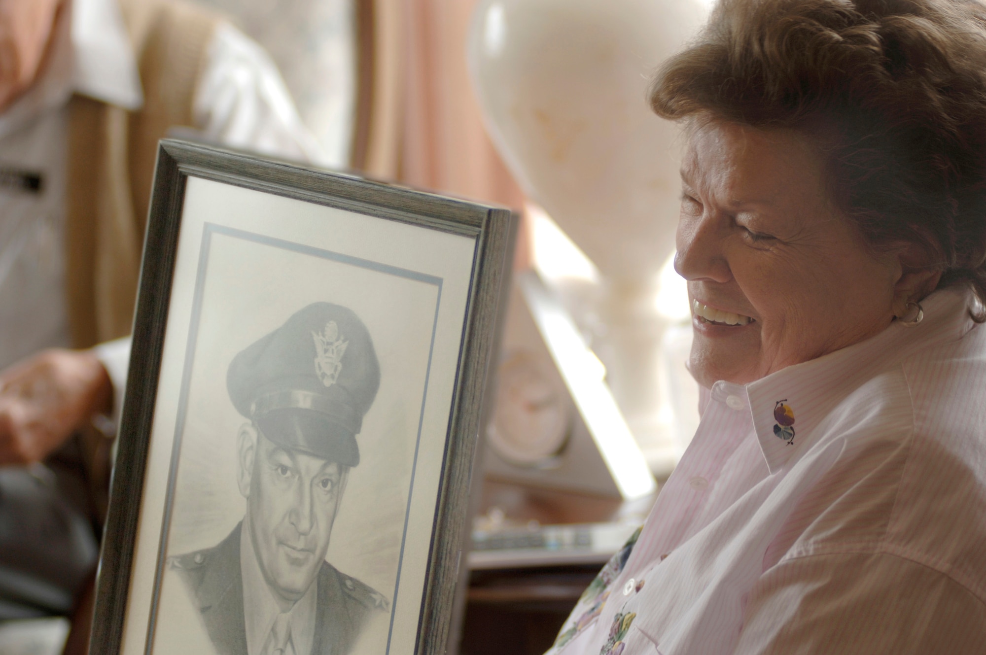 Margaret Ramey Watkins reminisces about the man in the portrait, her father, Brig. Gen. Howard K. Ramey. General Ramey was a founding member of the Order of Daedalians, a fraternal order of military pilots. (U.S. Air Force photo/Tech. Sgt. Cecilio M. Ricardo Jr.)
