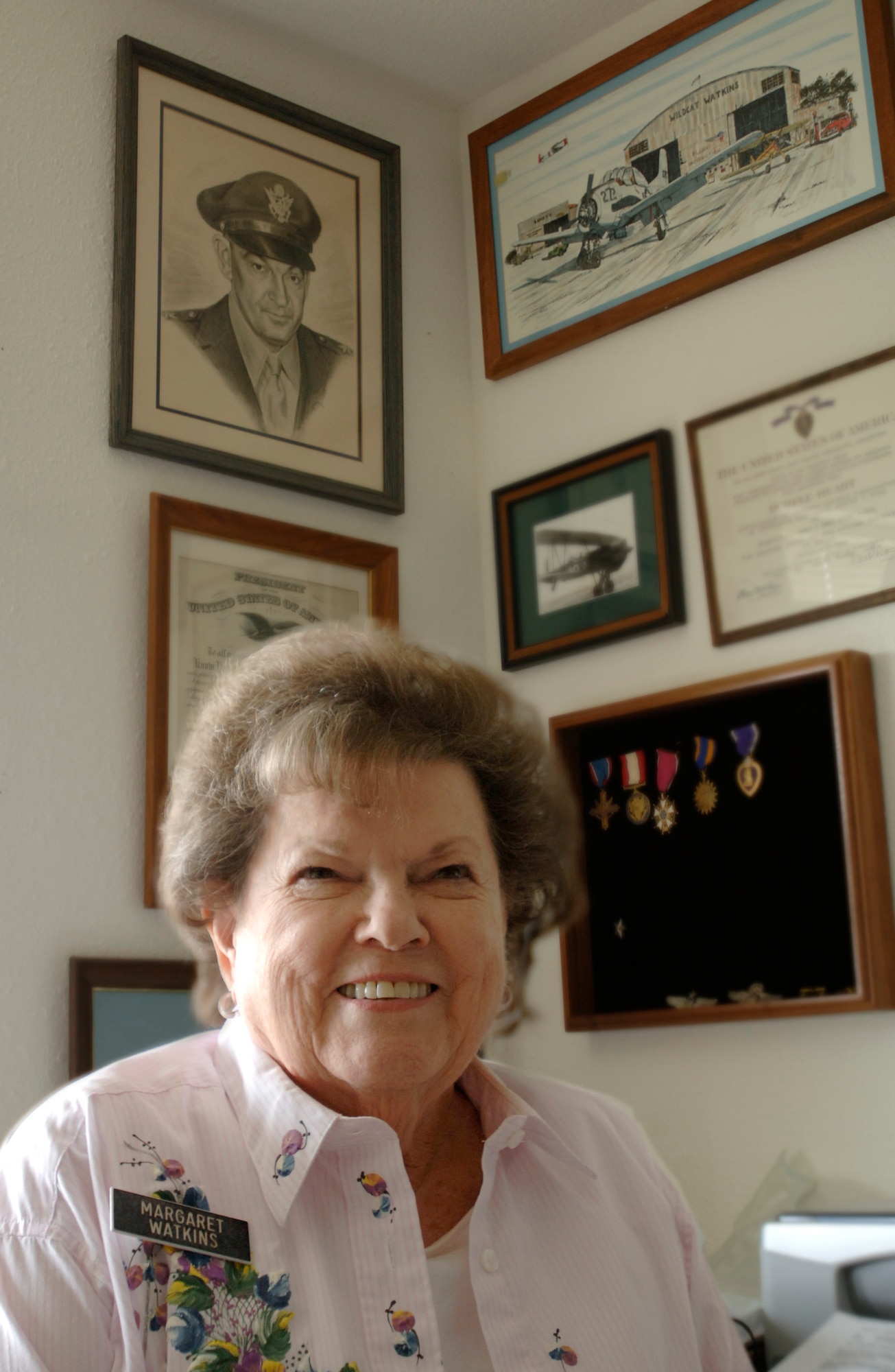 Margaret Ramey Watkins sits beneath a portrait of her father, Brig. Gen. Howard K. Ramey, at her home in San Antonio. General Ramey was a founding member of the Order of Daedalians, a fraternal order of military pilots. (U.S. Air Force photo/Tech. Sgt. Cecilio M. Ricardo Jr.)
