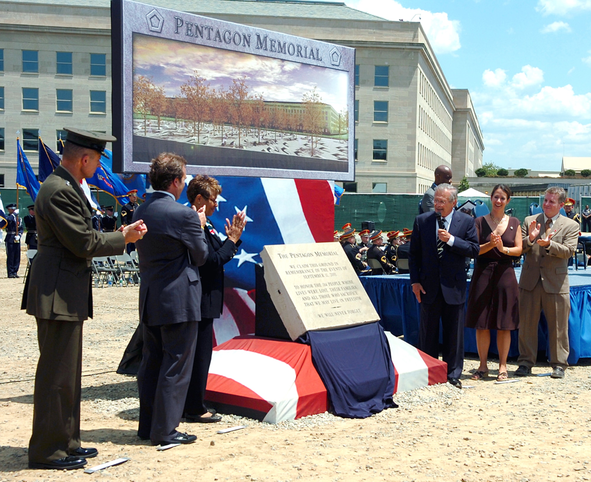 The memorial stone is unveiled Thursday, June 15, at the ceremony marking the start of construction on the Pentagon Memorial, located at the site where 184 lives were lost when American Airlines Flight 77 crashed on Sept. 11, 2001. From left are: U.S. Marine Corps Gen. Peter Pace, chairman of the Joint Chiefs of Staff; Jim Laychak, president of the Pentagon Memorial Fund; Rosemary Dillard, vice president of the Pentagon Memorial Fund; Secretary of Defense Donald H. Rumsfeld; and Julie Beckman and Keith Kaseman, Pentagon Memorial concept designers. (Department of Defense photo/Petty Officer 1st Class Chad J. McNeeley)