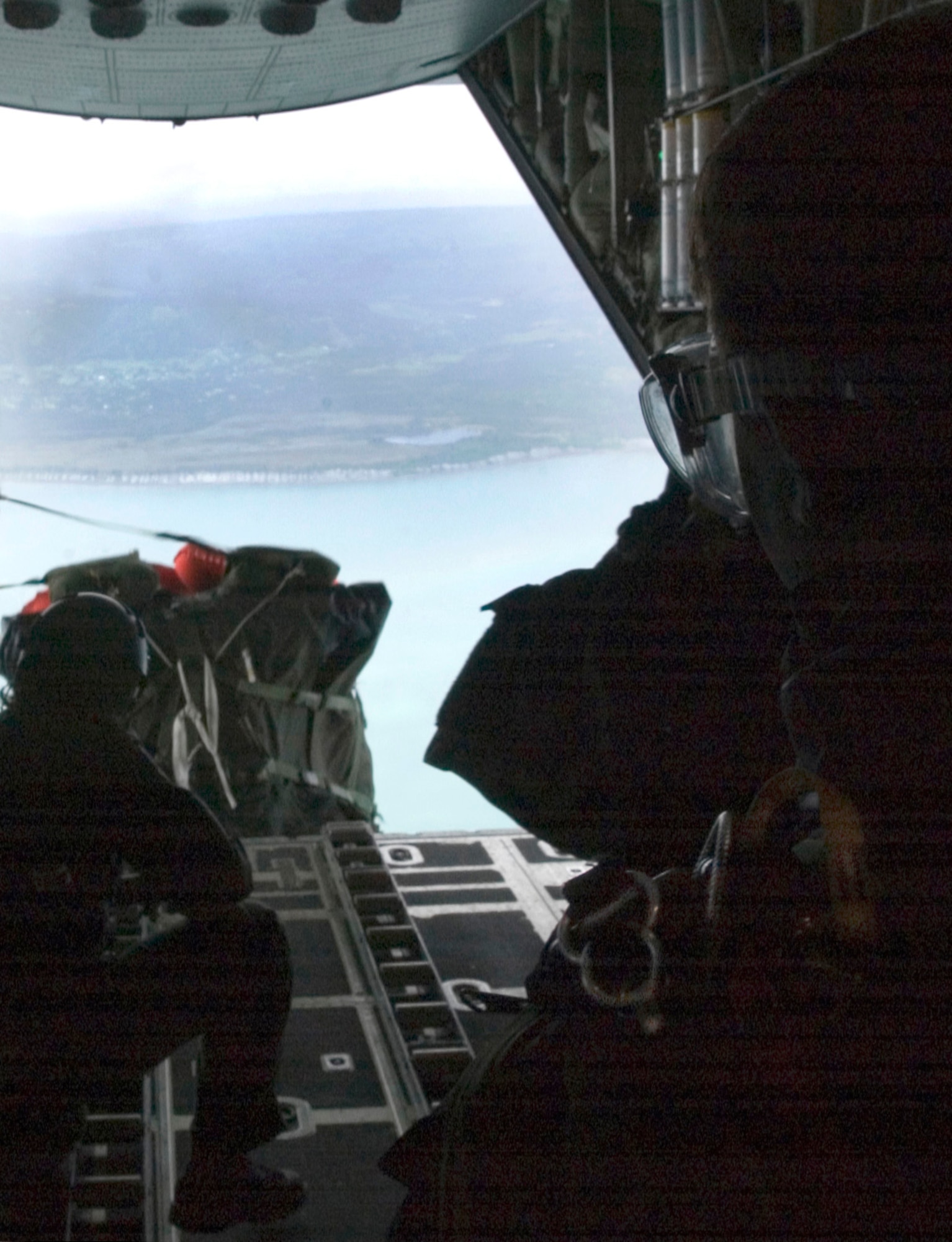 Loadmasters drop a Zodiac inflatable raft into Kachemak Bay from a HC-130 Hercules for three pararescuemen simulating downed pilots awaiting rescue in the water. Air Force pararescue jumpers assigned to bases in Japan and Alaska practiced an over-water rescue training scenario as part of Exercise Northern Edge 2006. (U.S. Marine Corps photo/Lance Cpl. Ethan Hoaldridge)