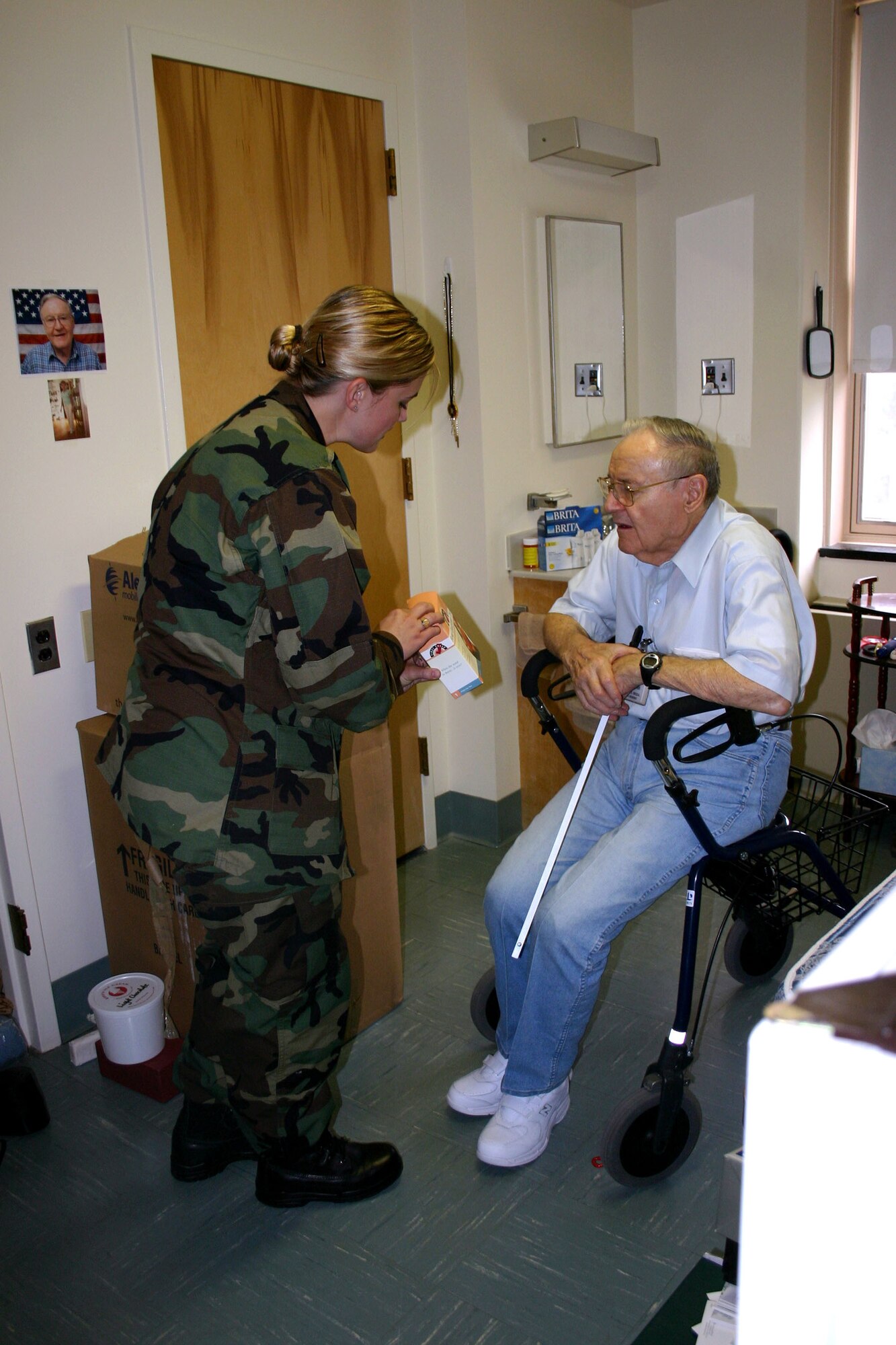 Capt. Lisa Reaver helps Leonard Drozal unpack his belongings at the Armed Forces Retirement Home in Washington, D.C., on Thursday, June 15. Mr. Drozal, a World War II Marine Corps veteran, evacuated here when the retirement home in Gulfport, Miss., was damaged during Hurricane Katrina. Captain Reaver is assigned to the Air Force Intelligence Analysis Agency. (Courtesy photo/Sheila Motley)
