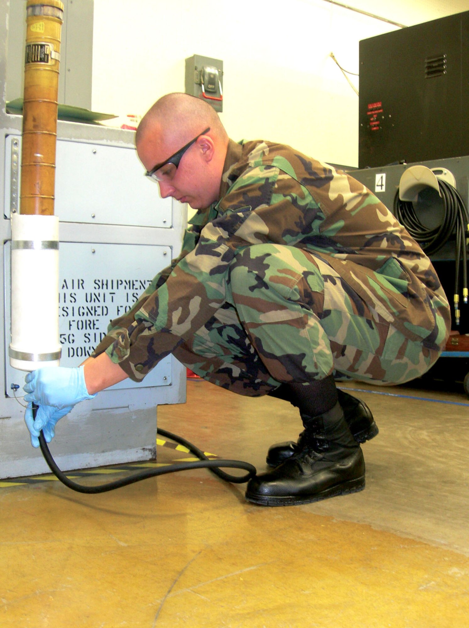 Airman 1st Class Nathaniel Dollar charges air into a flight control accumulator on the PVC-pipe container his shop created to make the maintenance process safer and more efficient. He is a hydraulics systems journeyman with the 56th Component Maintenance Squadron at Luke Air Force Base, Ariz. (U.S. Air Force photo by Capt. Chrissy Cuttita) 