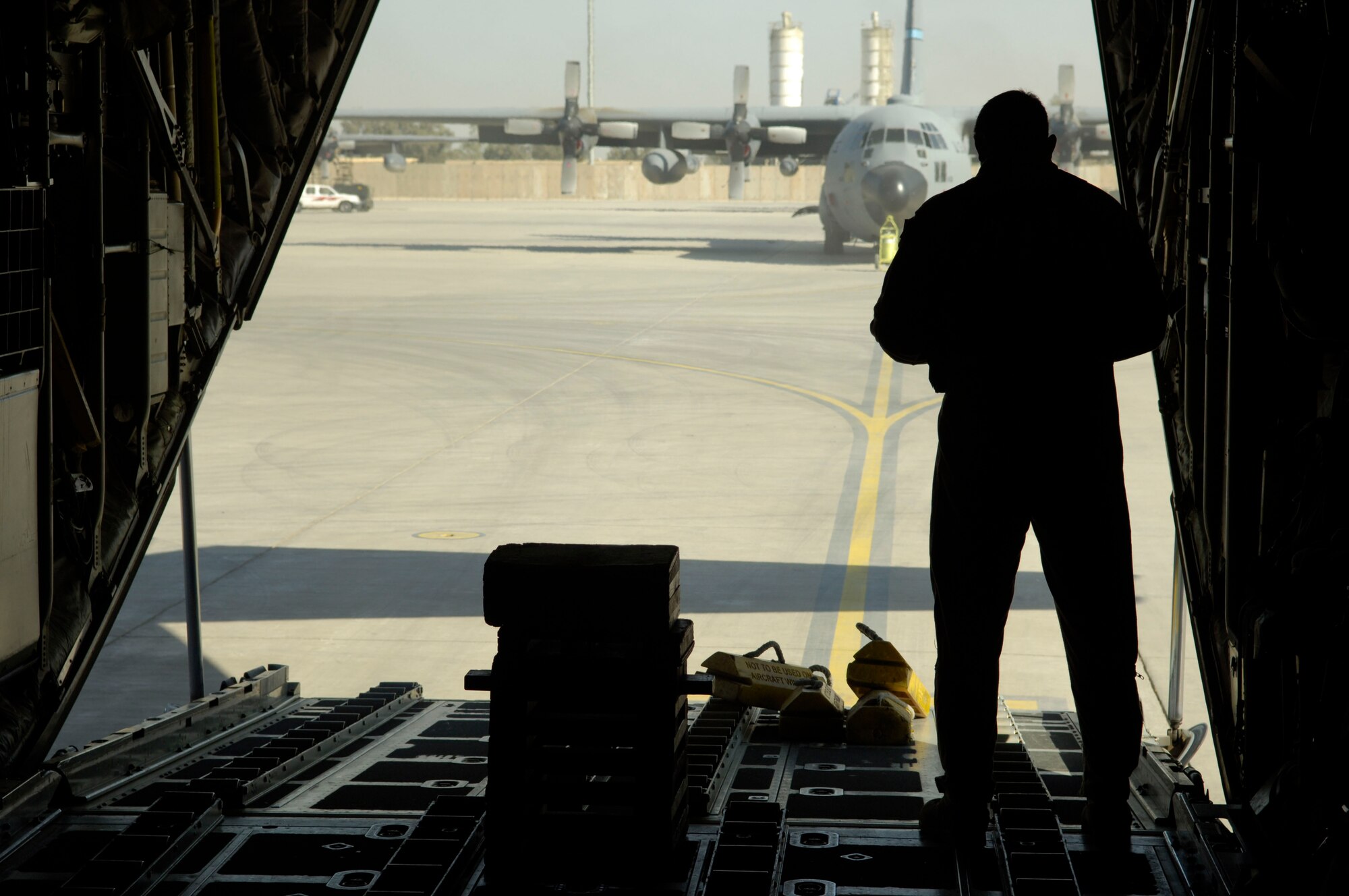 BALAD AIR BASE, Iraq -- A loadmaster assigned to the 777th Expeditionary Airlift Squadron makes final preparations for flight before the C-130 is sealed up for a mission. C-130s began operating here in January, the first time for a Hercules to operate from a foward-deployed location. (U.S. Air Force photo by Airman 1st Class Andrew Oquendo)
