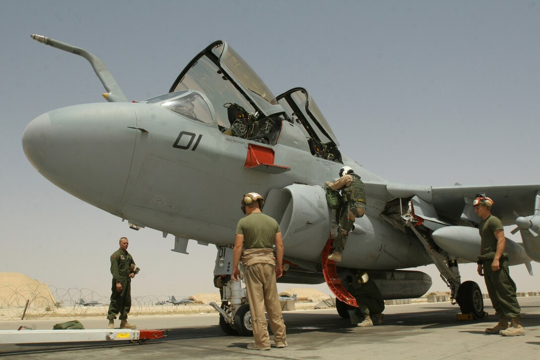 Powerline division Marines surround an EA-6B Prowler belonging to Marine Tactical Electronic Warfare Squadron 2, Marine Aircraft Group 16 (Reinforced), 3rd Marine Aircraft Wing, during the jet's recovery process at Al Asad, Iraq, June 18. The division's Marines are responsible for preflight and postflight inspections, engine maintenance, external and internal fuel system maintenance, as well as acting as the plane captains for the aircraft.