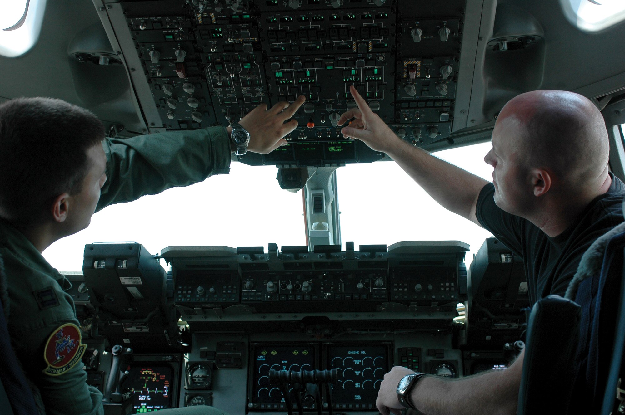 YOKOTA AIR BASE, Japan - Staff Sgt. Roy Eilenstine, right, recently returned to work as a crew chief in the 730th Air Mobility Squadron after donating bone marrow. He discusses a fuel transfer on a C-17 Globemaster II aircraft with Capt. Glenn Garcia (left), a pilot from the 10th Airlift Squadron out of McChord Air Force Base, Wash. (Photo by Staff Sgt. Karen J. Tomasik)