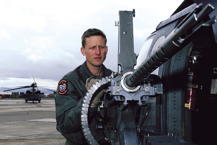 NELLIS AIR FORCE BASE, Nev. -- Staff Sgt. Jason Parker, 66th Rescue Squadron aerial gunner, performs a pre-flight check on a 50-caliber machine gun mounted on an HH-60G Pavehawk helicopter. The squadron, based at Nellis AFB, Nev., provides worldwide rescue support for the combat air forces. A typical crew consists of a pilot, co-pilot, aerial gunner, flight engineer and two pararescuemen.