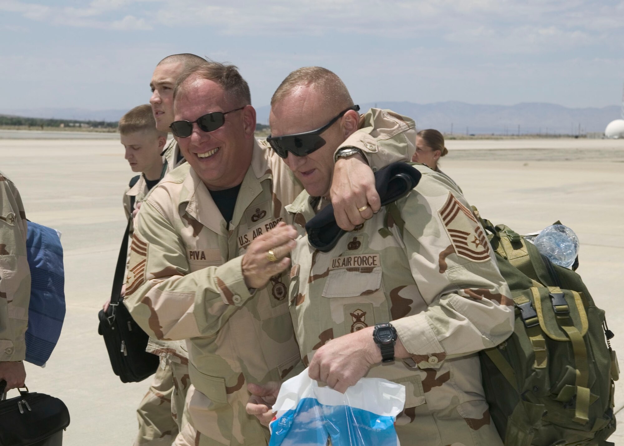 EDWARDS AIR FORCE BASE, Calif. — (Left) Chief Master Sgt. John Piva, 99th Ground Combat Training Squadron, Nellis Air Force Base, Nev., puts his arm around Chief Master Sgt. Anthony Danford, 99th Security Forces Group, as they walk off a DC-10 at Edwards Air Force Base, Calif., June 9. The Nellis chiefs landed at Edwards after returning from a deployment to Afghanistan. (Air Force photo by Bobbi Zapka). 