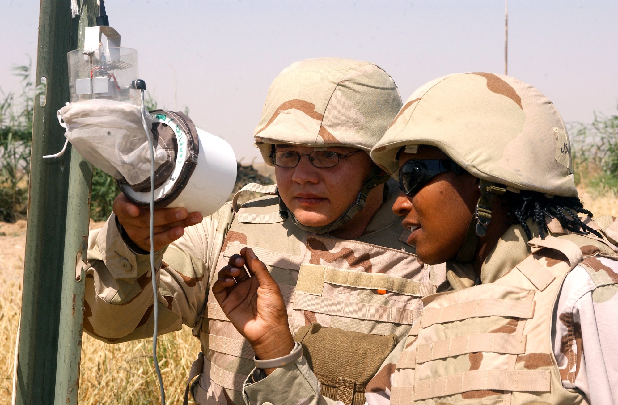 Senior Airmen Robert Lopez, left, and Denika Randle check insect traps for mosquitoes at Kirkuk Air Base, Iraq. The Airmen are assigned to the 506th Expeditionary Civil Engineer Squadron pest management section. (U.S. Air Force photo/Senior Airman Angelita Collins) 
