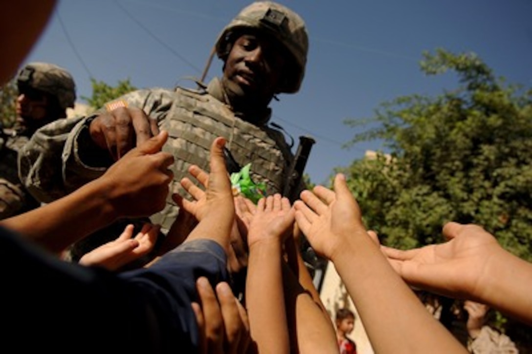 A sea of small hands surrounds Army Capt. David Best as he passes out candy to Iraqi children during a foot patrol in Badush, Iraq, on June 16, 2006. Best is a platoon leader from Bravo Company, 1st Battalion, 17th Infantry Regiment, 172nd Stryker Brigade Combat Team, based out of Fort Wainwright, Alaska. 