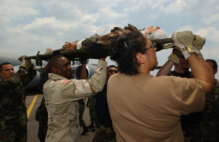 Air Force and Army medical people simulate loading and unloading of patients from an aircraft to a bus in Augusta Regional Airport, Busch Field, Ga., June 16, during Golden Medic 2006, an annual medical exercise. (U.S. Air Force photo/Senior Airman Jacqueline Kabluyen)