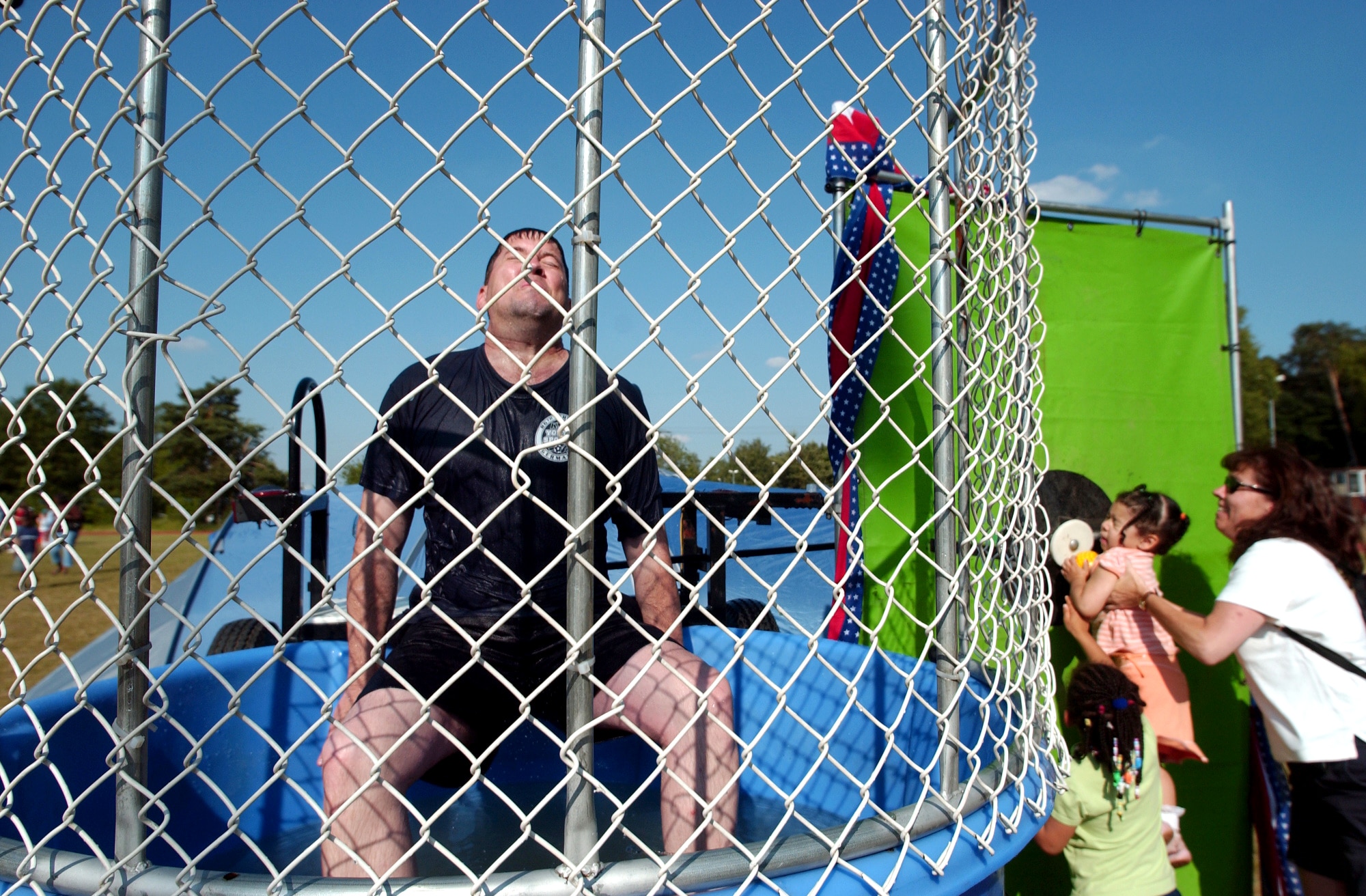 Tech. Sgt. William Kelso braces to get dunked by 2-year-old Mya Talbert at the World Cup Fest at Pulaski Park in Kaiserslautern, Germany, on Saturday, June 17. She is held by her mom, Master Sgt. Suzanne Talbert, from the 723rd Air Mobility Squadron at Ramstein Air Base, and encouraged by her sister, 5-year-old Rene. Sergeant Kelso is assigned to Headquarters U.S. Air Forces in Europe. (U.S. Army photo/Christine June) 
