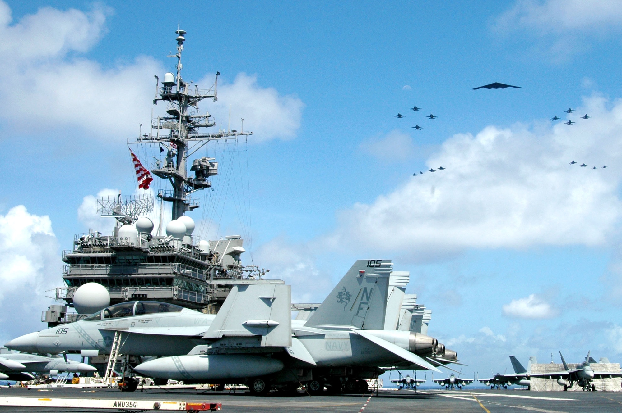 A B-2 Spirit and 16 other aircraft from the Air Force, Navy and Marine Corps fly over an aircraft carrier in the western Pacific Ocean on Sunday, June 18, to kick off Exercise Valiant Shield 2006. The joint exercise consists of 28 naval vessels, more than 300 aircraft and approximately 20,000 servicemembers. (U.S. Navy photo/Photographer's Mate Airman Benjamin Dennis)