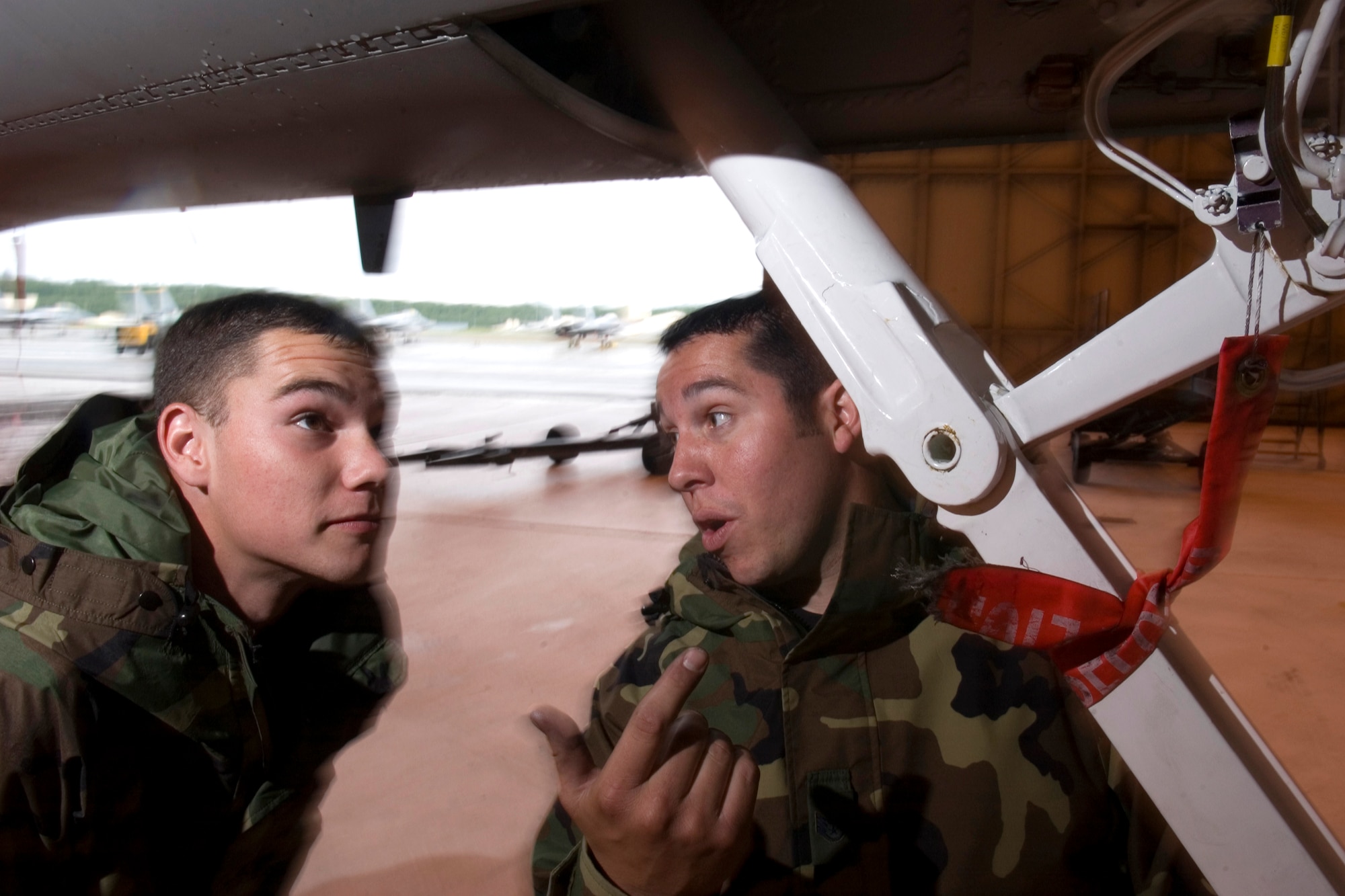 ELMENDORF AFB, Alaska -- Airman 1st Class Benjamin Crochet, with the 12th Aircraft Maintenance Unit here, receives detailed information about the mechanics of the landing gear on an F-15 from Staff Sgt. Dwayne Lujan during some down time. All aircraft were on standby due to bad weather during Northern Edge, which concludes June 16.  The exercise is one of a series of U.S. Pacific Command exercises this year that prepare joint forces to respond to crises in the Asian Pacific region.  (U.S. Air Force Photo by Senior Airman Garrett Hothan) (RELEASED)